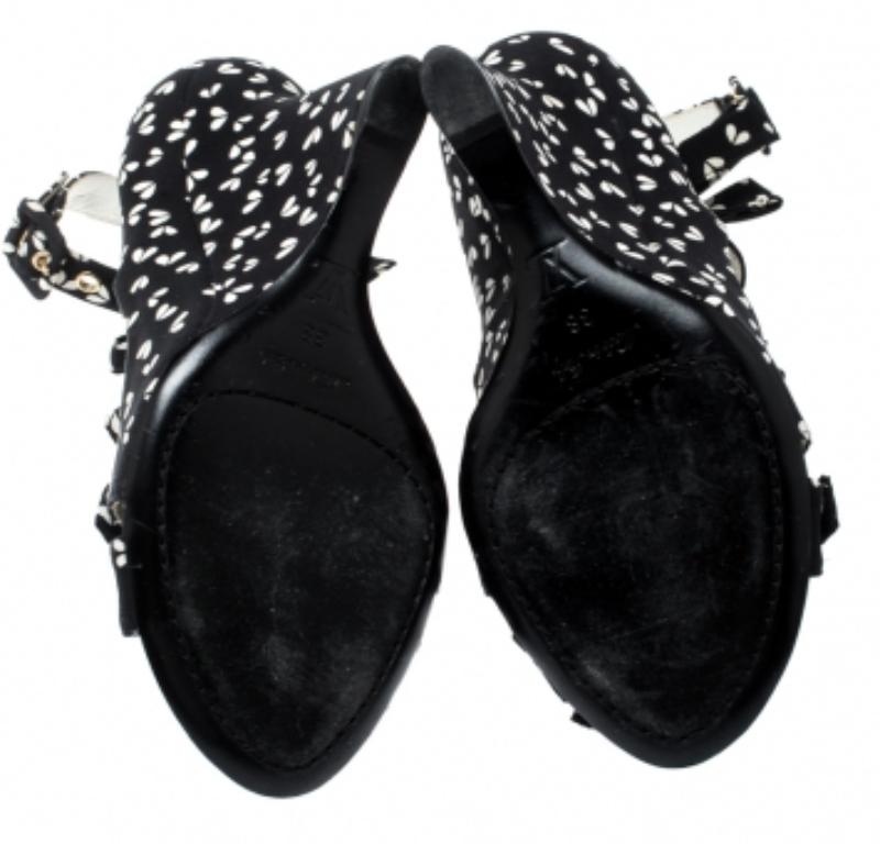 Diese Sandalen aus dem Modehaus Louis Vuitton wurden aus bedrucktem Stoff gefertigt und mit drei Schleifenbändern, Schnallenverschlüssen und Keilabsätzen versehen. Kombinieren Sie sie mit Denim-Jeans oder Röcken für einen trendigen Look.