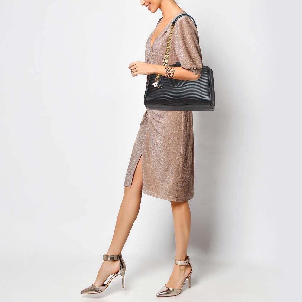 First released in 2018 the New Wave collection of bags carry a mixed design of both classic and edgy. This bag is crafted from black leather carrying a distinct wavy quilt pattern all over. The bag has the LV logo on the front and an Alcantara