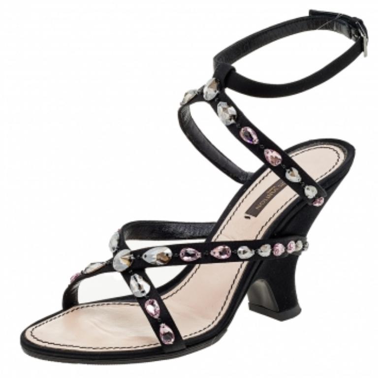 Charm your way to all your social gatherings in this pair of slide sandals from Louis Vuitton. Crafted from black satin, they carry a smart design with open toes, embellishments on the straps, and sturdy heels. Comfortable insoles make them a pair