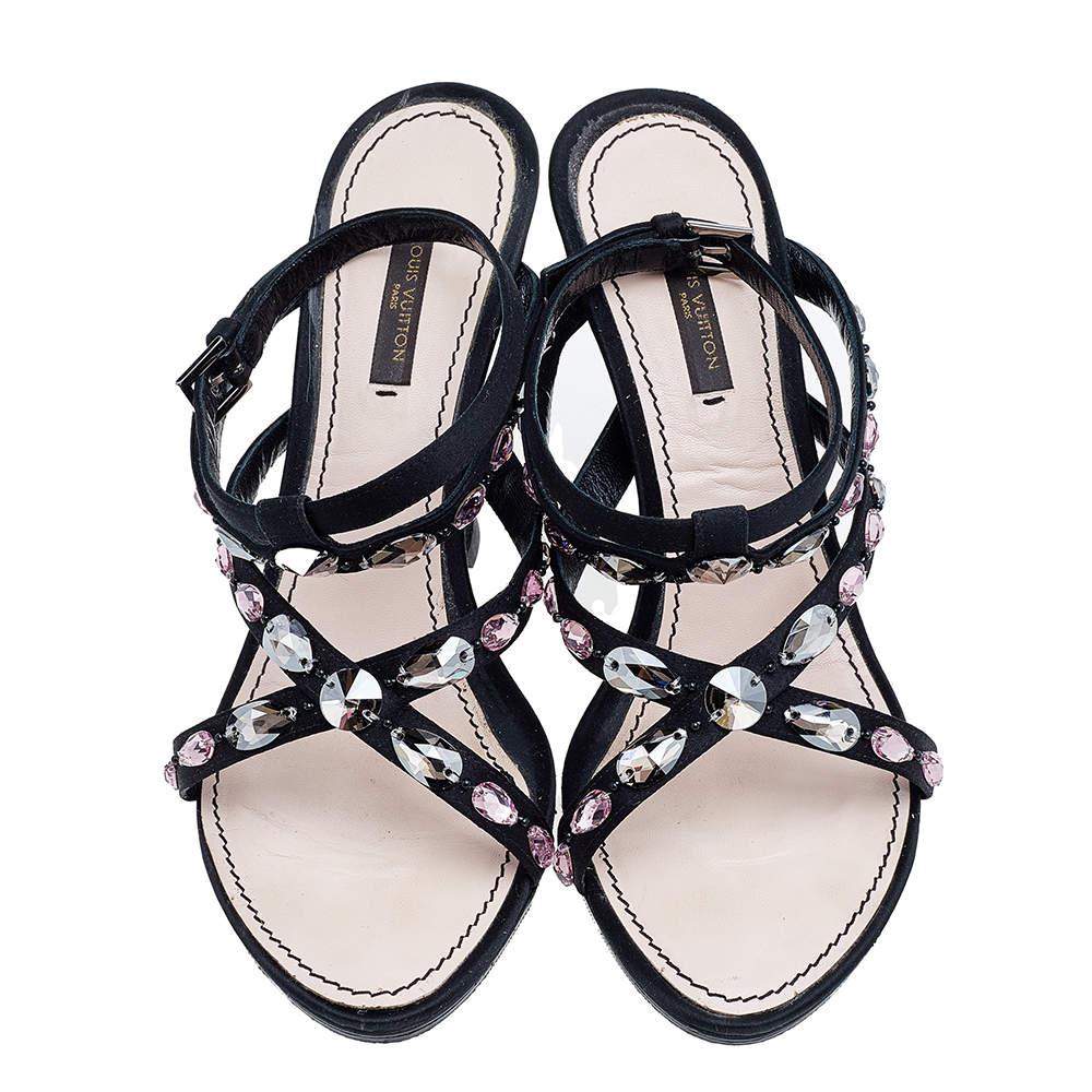 Charm your way to all your social gatherings in this pair of slide sandals from Louis Vuitton. Crafted from black satin, they carry a smart design with open toes, embellishments on the straps, and sturdy heels. Comfortable insoles make them a pair