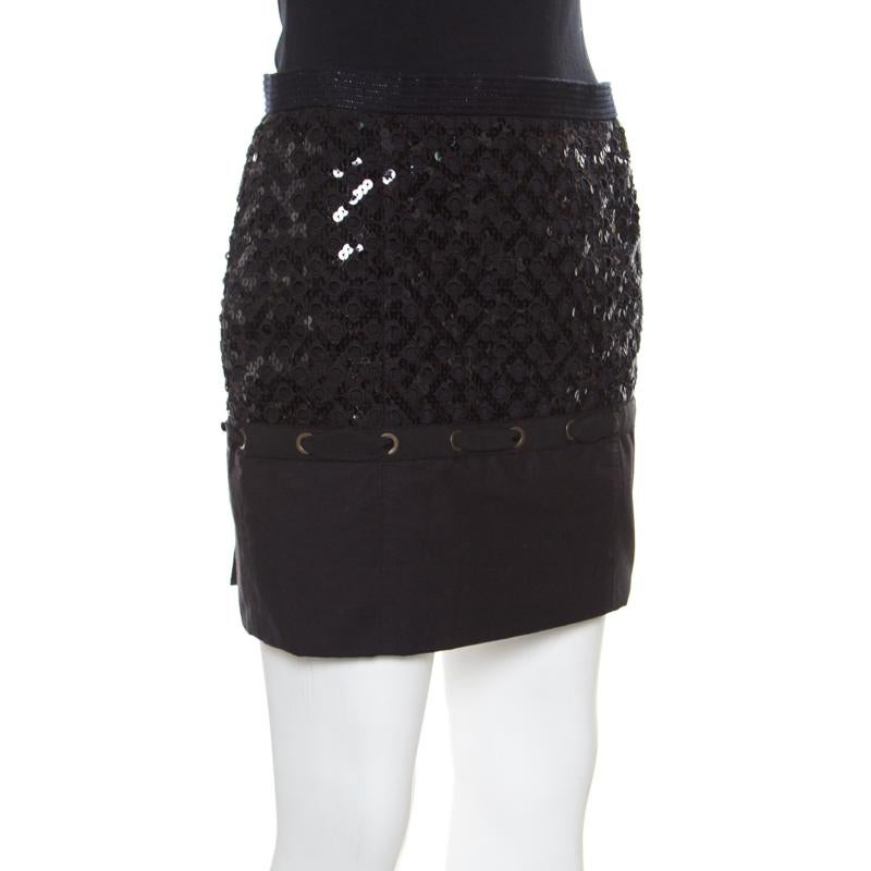 Louis Vuitton's expertise in designing clothing that is wearable and comfortable without compromising on style includes this black mini skirt. It is made from quality fabrics and designed with sequins embellished in grids, an eyelet lace panel, and