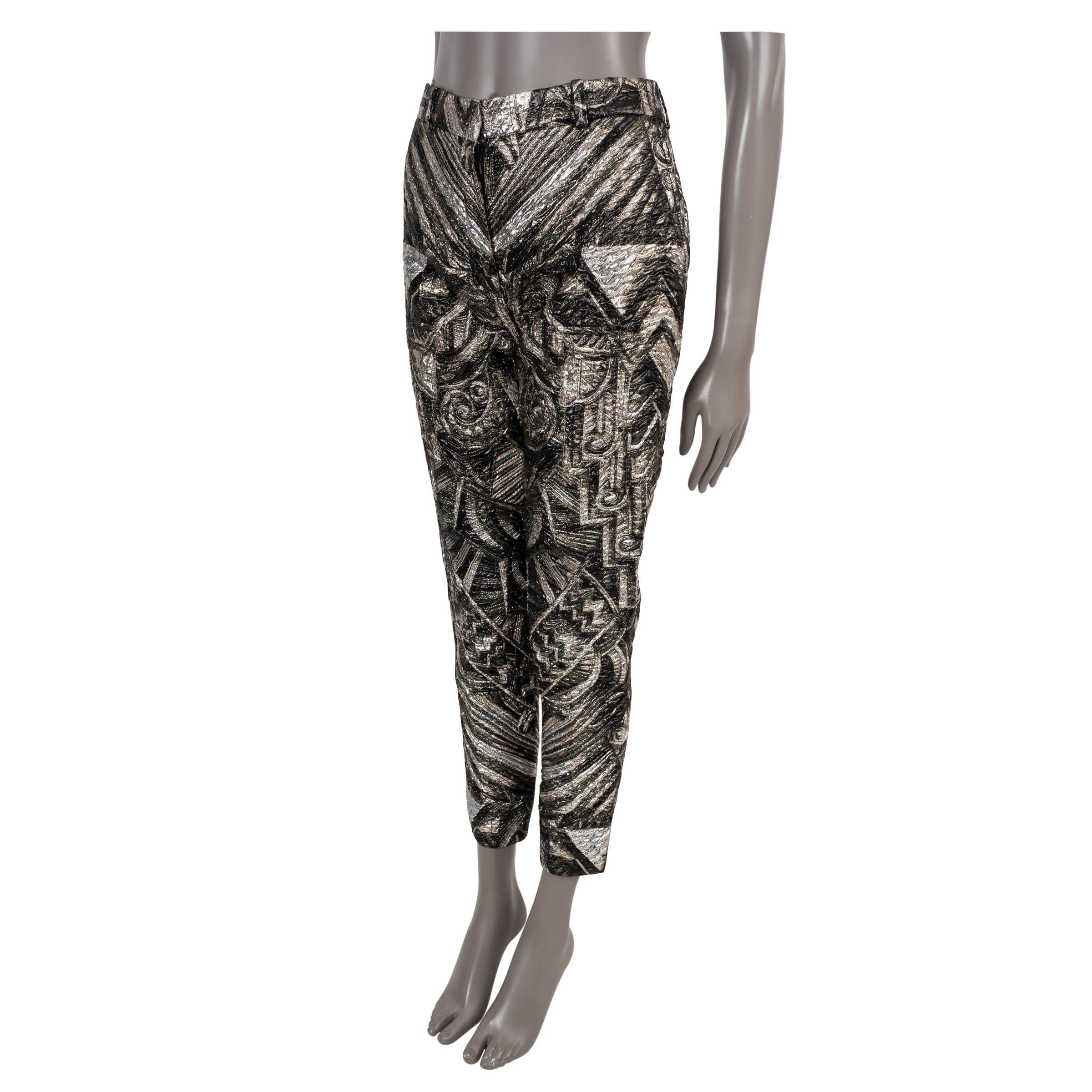 Pantaloni 100% autentici di Louis Vuitton in broccato nero e argento metallizzato in poliestere (54%), poliammide (33%) e seta (13%). Presenta una vita alta, una gamba affusolata e due tasche oblique in vita. Si chiude con un bottone e una cerniera