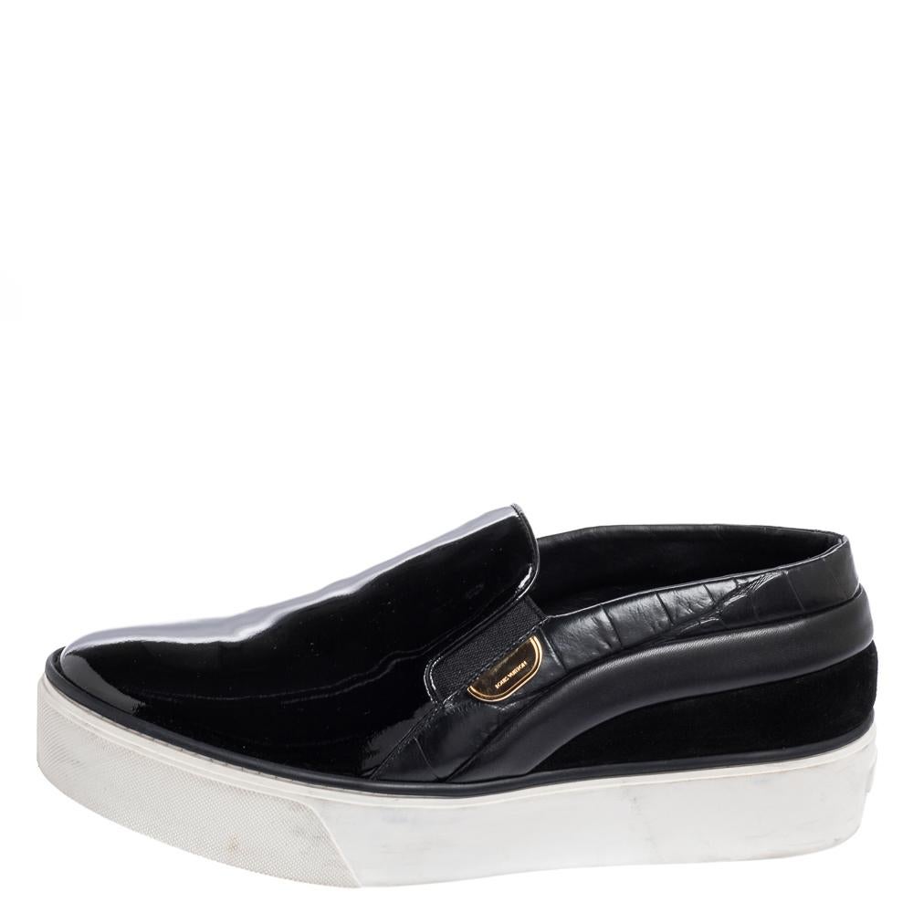 Queste sneakers della Maison Louis Vuitton sono una creazione che non puoi assolutamente perdere! Sono state create utilizzando vernice nera, pelle e pelle scamosciata all'esterno. Hanno uno stile slip-on, hardware color oro e plateau. Abbina queste