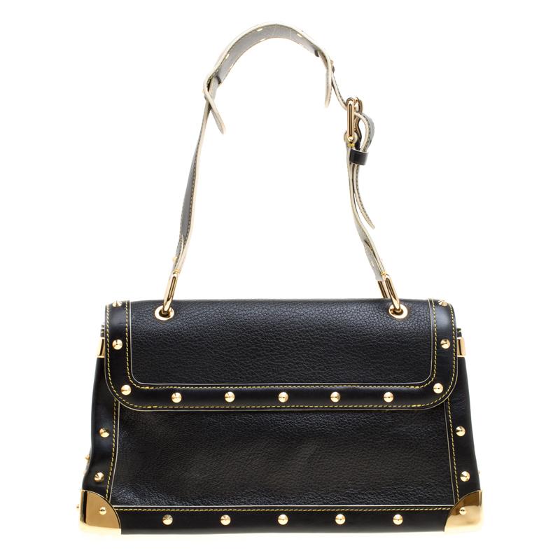 This Suhali Le Talentueux bag from Louis Vuitton is gorgeous. The black beauty is crafted from leather and flaunts a unique and distinctive style. It features beautiful gold-tone pyramid studs, a push lock closure, rings and metal reinforced edges,