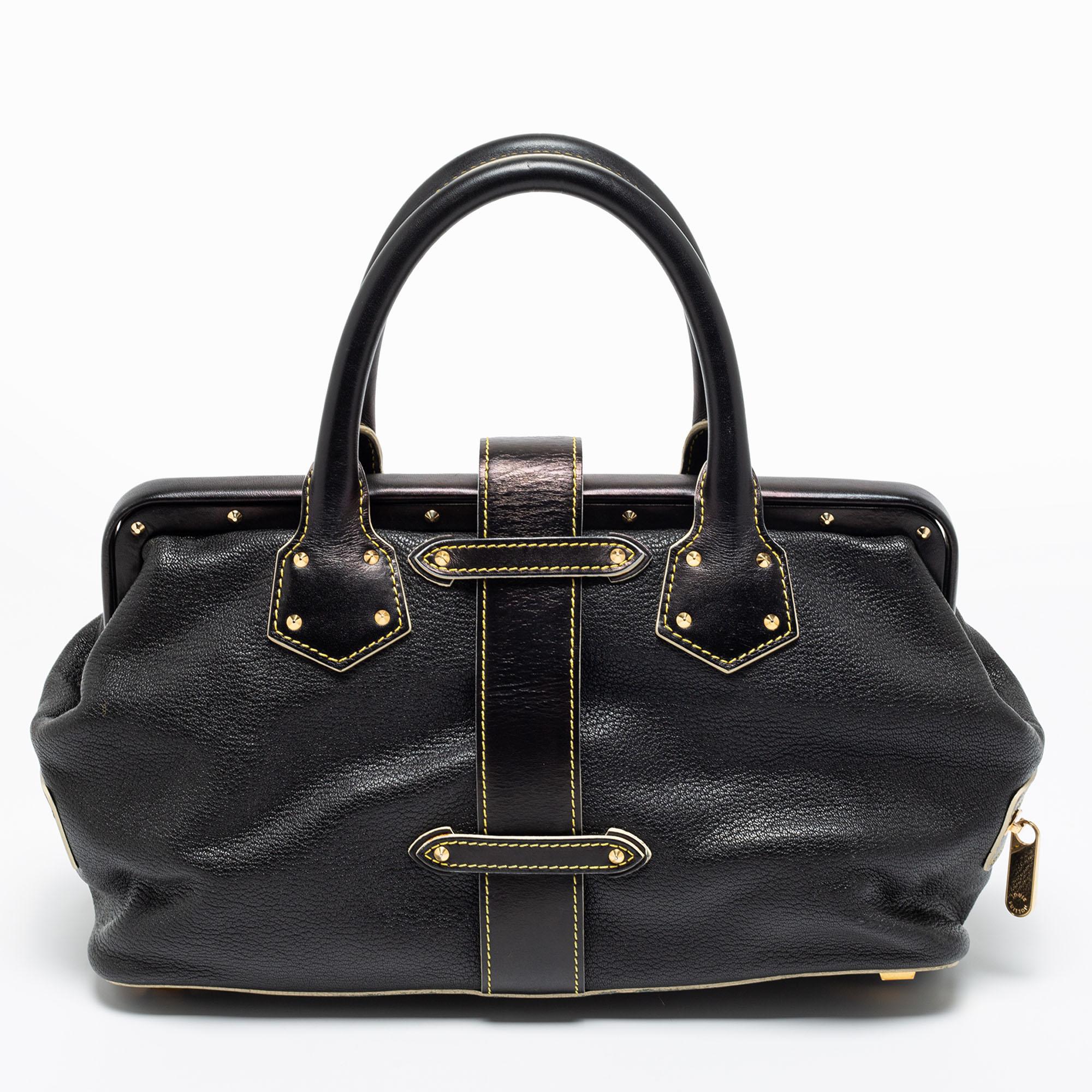 This Louis Vuitton L'Ingenieux bag is crafted to perfection. Made of black Suhali leather, it is adorned with gold-tone studs, a signature lock with the brand insignia, and side zip pockets. The capacious interior is lined with fabric. Dual handles