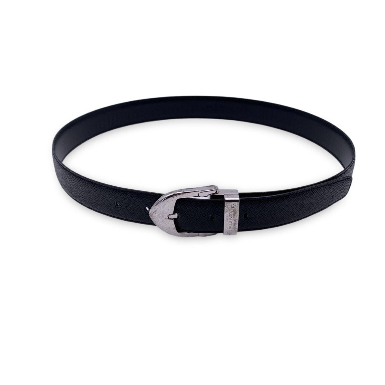 LOUIS VUITTON black taiga 'Ceinture Classic' leather belt. The belt features a silver metal buckle with engraved 'Louis Vuitton' signature. Five holes adjustment. Size 85/34. Width: 1.1 inches - 3 cm. Total length: 38 inches - 96.5 cm (only
