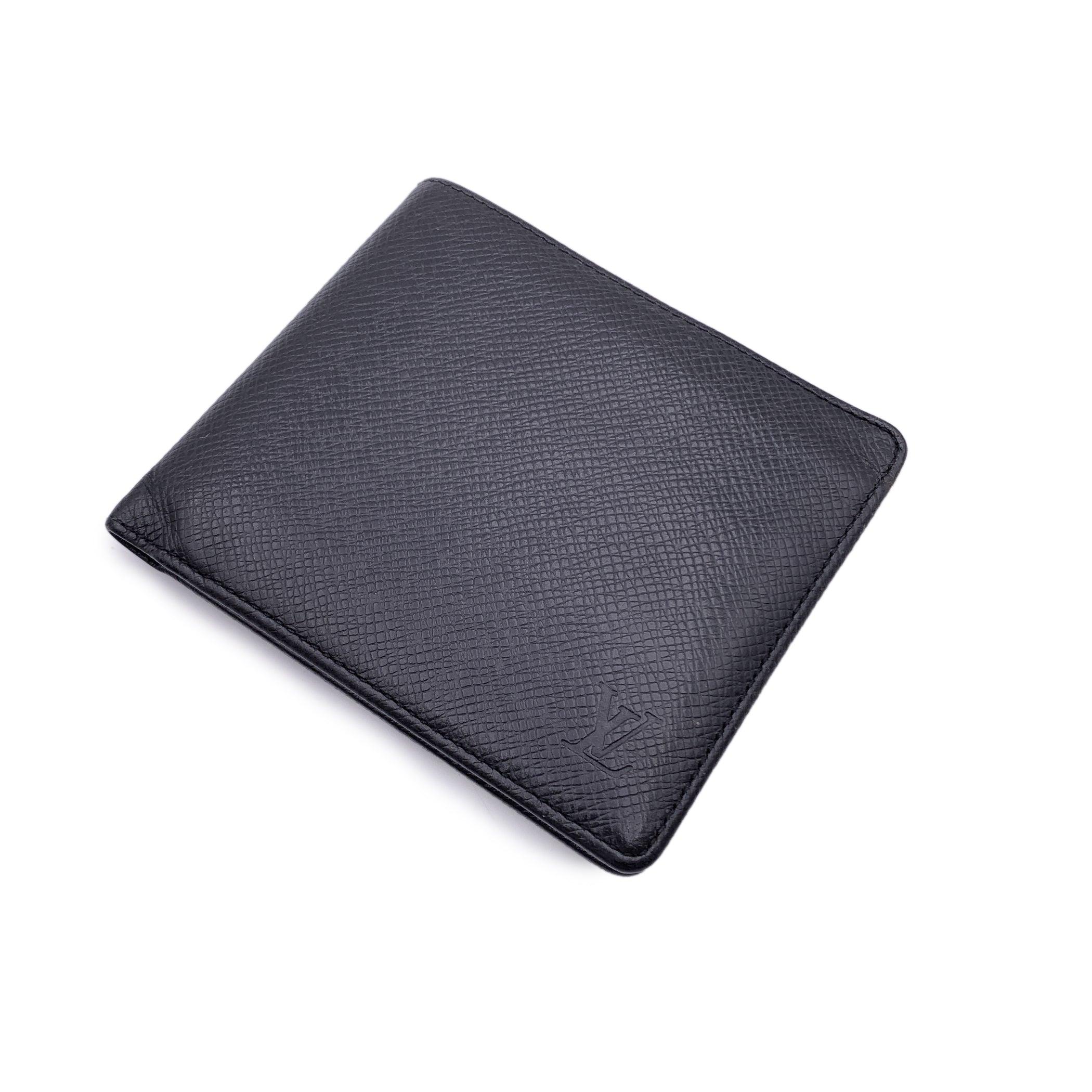 Louis Vuitton black taiga leather Card and Bill Holder Bifold Wallet. Bifold design. 2 bill compartments, 5 credit card slots and 2 open pockets inside. Leather lining. 'LOUIS VUITTON Paris - made in France' embossed inside. Authenticity serial