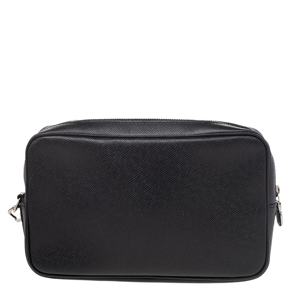 This pouch from Louis Vuitton is made from Taiga leather. It has a convenient strap that can be used to carry it as a wristlet. It has a fabric & leather-lined interior that is secured by a zip closure. This pouch has a structured shape.

Includes: 