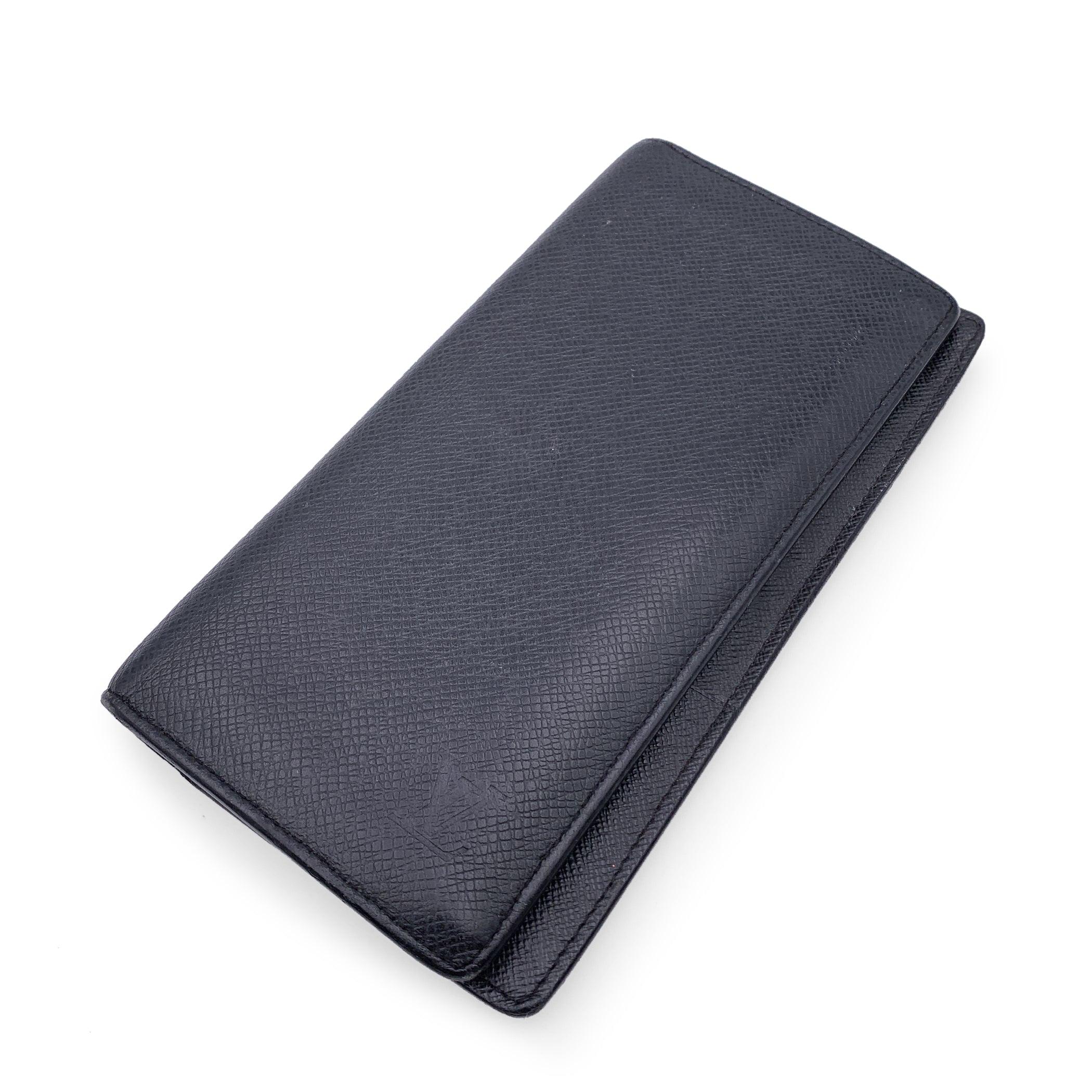 Louis Vuitton Black Taiga Long Continental Brazza Wallet. Bifold design. Leather lining. 12 credit card slots, 1 zip compartment , 3 flat pockets, 2 long compartments for bills.'LOUIS VUITTON Paris - made in France' embossed inside. Authenticity