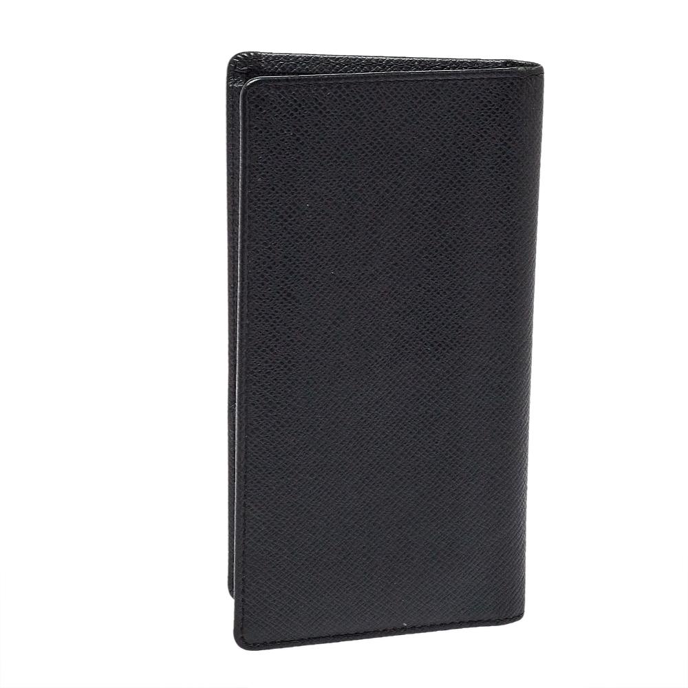 Louis Vuitton brings you this lovely wallet that has been made in France using leather. It has a bi-fold that opens to reveal multiple slots and compartments for you to neatly arrange your cash and cards. The black Taiga wallet is complete with the