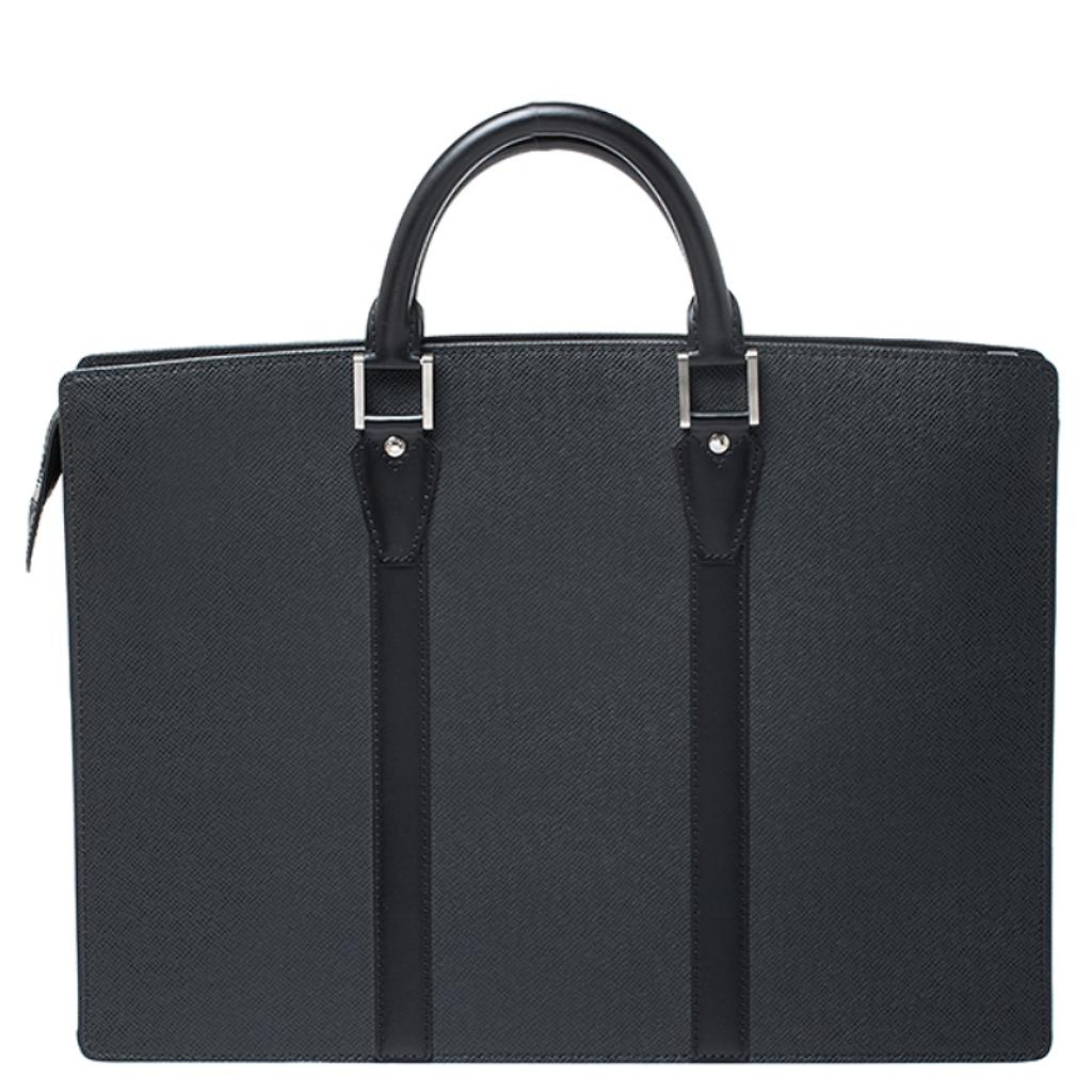 This Louis Vuitton briefcase brings such a grand shape that you're sure to look fashionable whenever you carry it. It has been crafted from black Taiga leather and designed with two top handles and canvas compartments where you can carry your