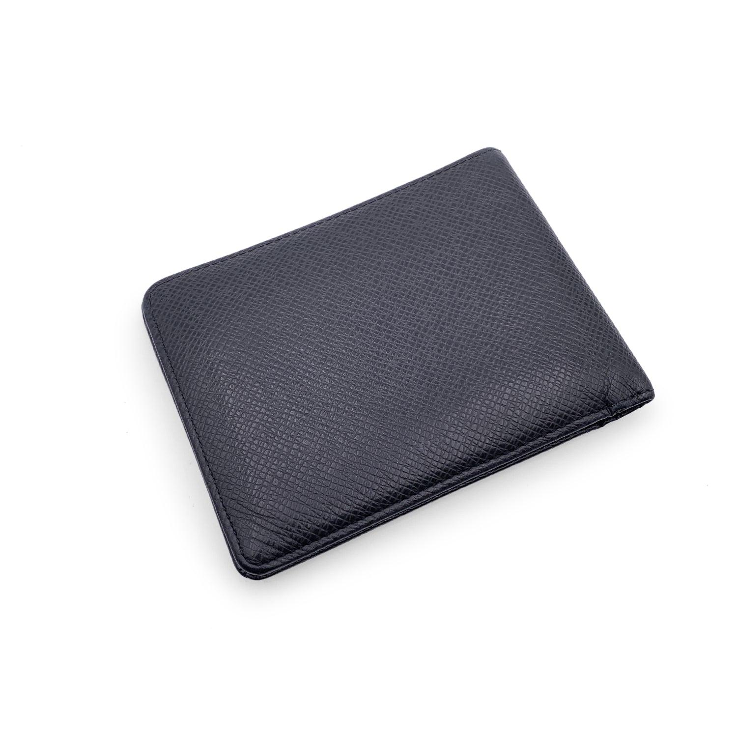 Louis Vuitton cuir noir taïga Multiple Bifold Wallet Credit Card Holder. Design/One. 2 compartiments à billets, 5 fentes pour cartes de crédit et 2 poches ouvertes à l'intérieur. Doublure en cuir. Intérieur embossé 'LOUIS VUITTON Paris - made in