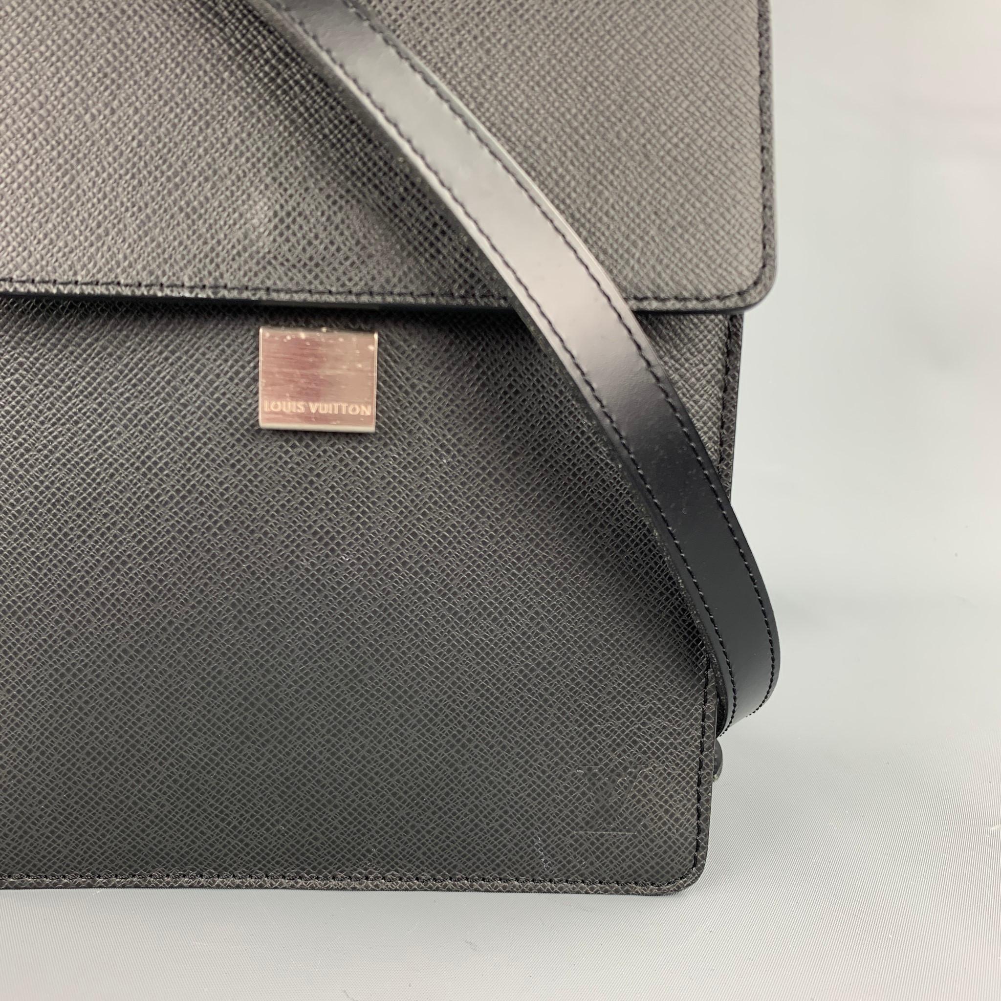 LOUIS VUITTON shoulder bag comes in a black textured taiga leather featuring an adjustable shoulder strap, silver tone hardware, inner pocket, and a clasp closure. Made in France.

Very Good Pre-Owned Condition.
Marked:
