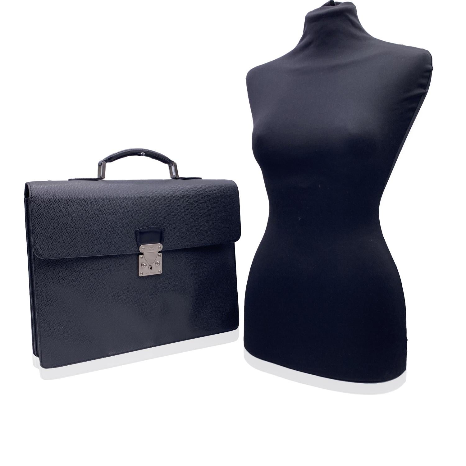 Classic and elegant 'Robusto 2' Briefcase work bag by Louis Vuitton. Crafted in black Taiga leather. Silver metal hardware. Flap closure with press key lock closure on the front (keys are included). Rear open pocket. 2 main internal compartments,