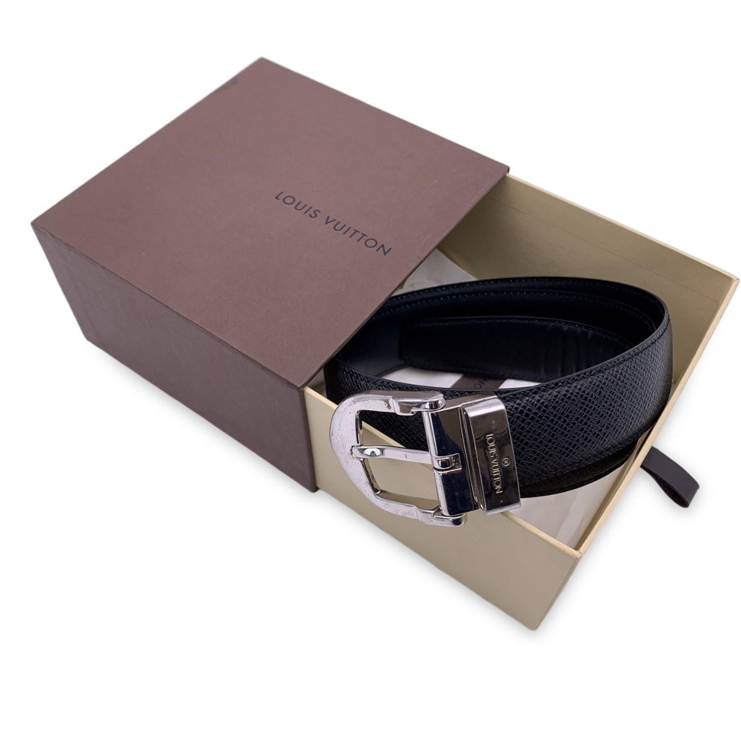LOUIS VUITTON black taiga 'Ceinture Classic' leather belt. The belt features a silver metal buckle with engraved 'Louis Vuitton' signature. Five holes adjustment. Size 85/34. Width: 1.1 inches - 3 cm. Total length: 38 inches - 96.5 cm (only