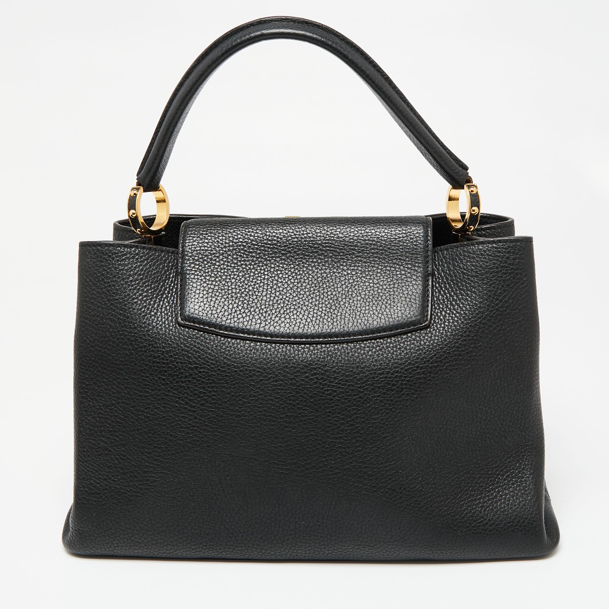 It is every woman's dream to own a Louis Vuitton handbag as appealing as this one. Crafted from leather, this bag features a structured design with a single handle and protective metal feet. While the front LV motif elevates its beauty, the leather