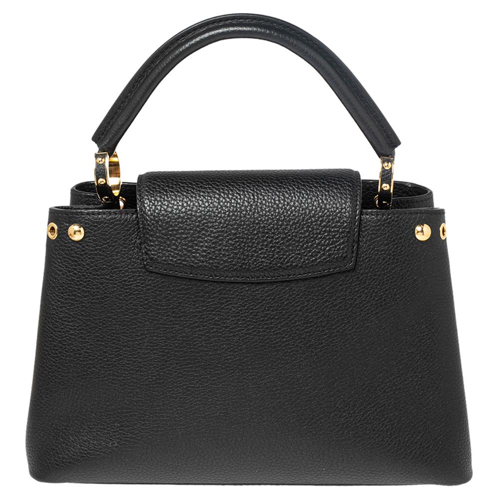 It is every woman's dream to own a Louis Vuitton handbag as appealing as this one. Crafted from leather, this Capucines bag features a structured design with a single handle and protective metal feet. While the front LV and gold-tone hardware