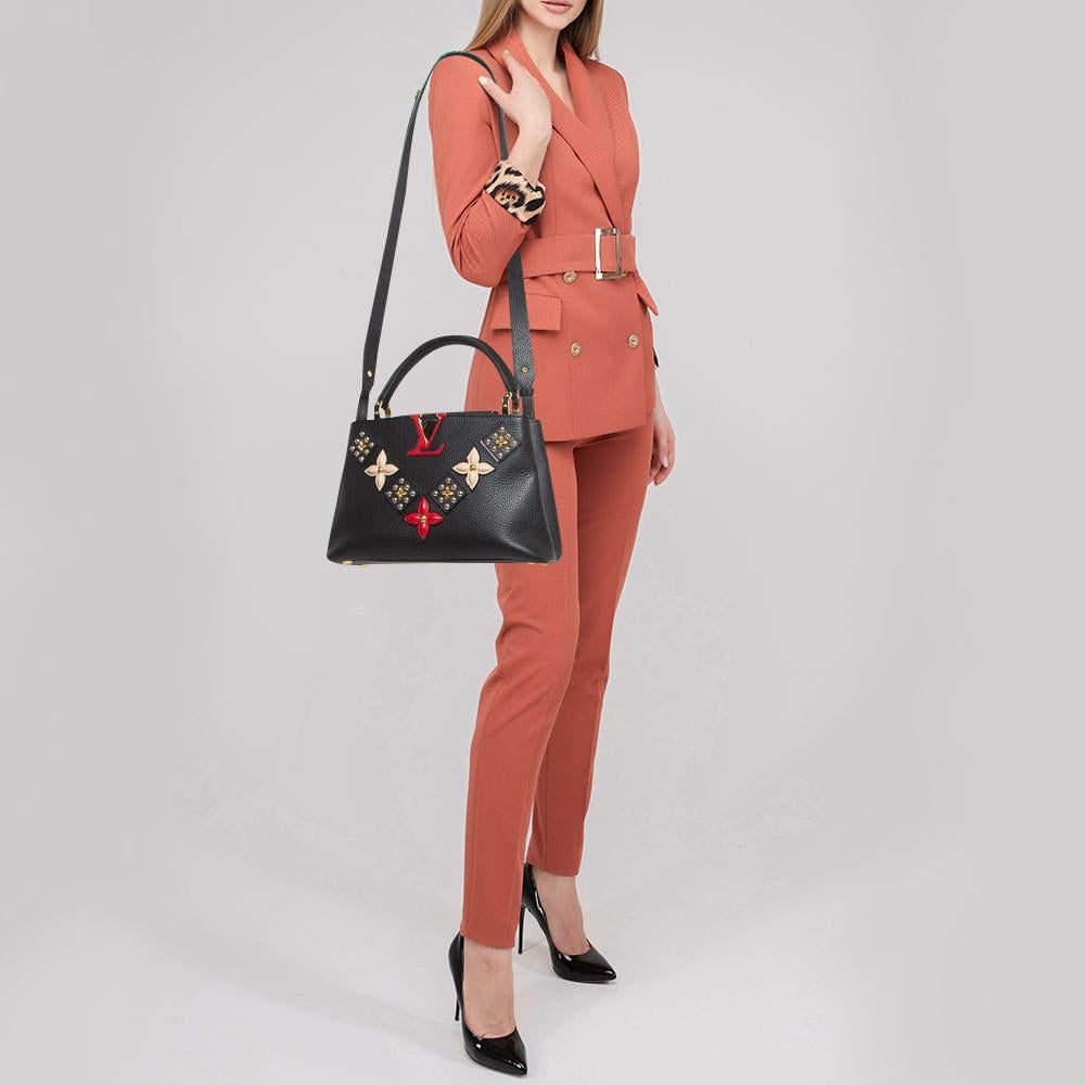 The Louis Vuitton Capucines bag is a luxurious accessory crafted from exquisite rubis red Taurillon leather. It features a sophisticated flap closure double handles and a distinctive LV monogram closure. The interior is lined with fine leather