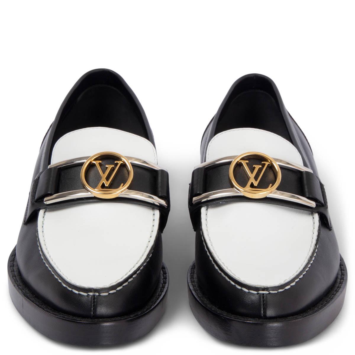 100% authentic Louis Vuitton Academy flat loafer in black and white calf leather brings a chic twist to a boyish classic. It is embellished with an LV accessory in gold- and silver-tone metal, which was inspired by the clasp of the iconic Dauphine