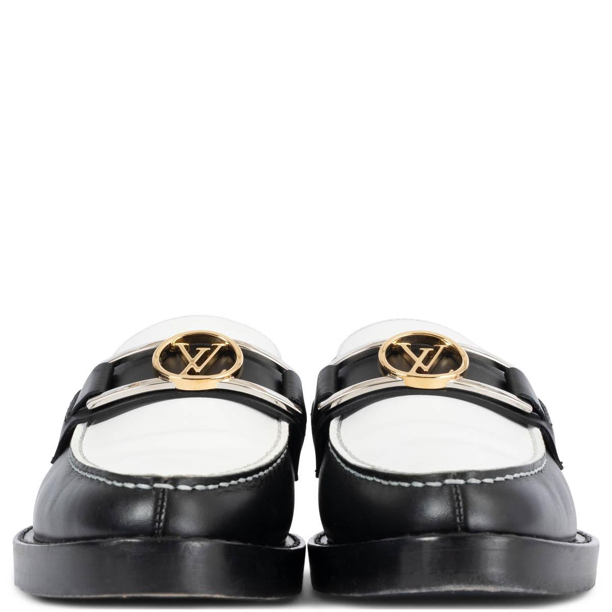 100% authentic Louis Vuitton Academy flat loafer in black and white calf leather brings a chic twist to a boyish classic. It is embellished with an LV accessory in gold- and silver-tone metal, which was inspired by the clasp of the iconic Dauphine