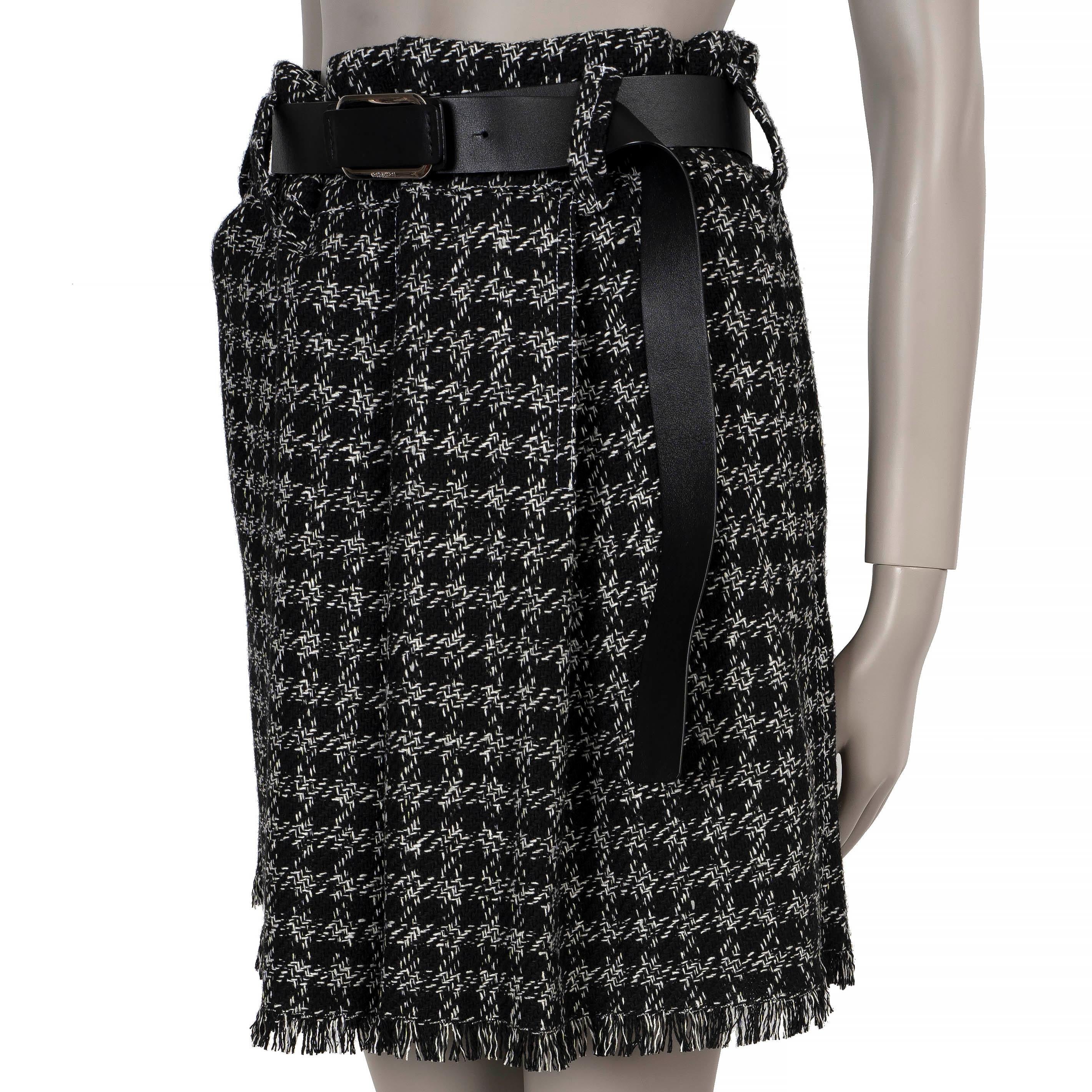 This 100% authentic Louis Vuitton pleated skirt in black and white houndstooth tweed is crafted from a luxurious blend of wool (64%), viscose (22%), polyamide (10%), and silk (4%). It features a chic fringed hem, slit pockets, and closes with a