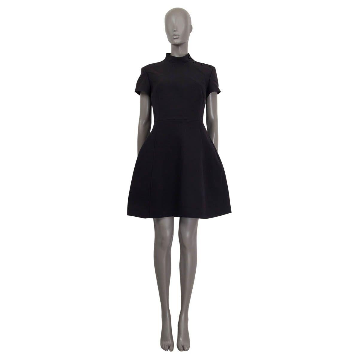 100% authentic Louis Vuitton a-line dress in black wool (64%) and silk (36%). Features short sleeves and a high neck. Opens with zipper on the back and four buttons on the shoulder. Lined in black silk (100%). Has been worn and is in excellent