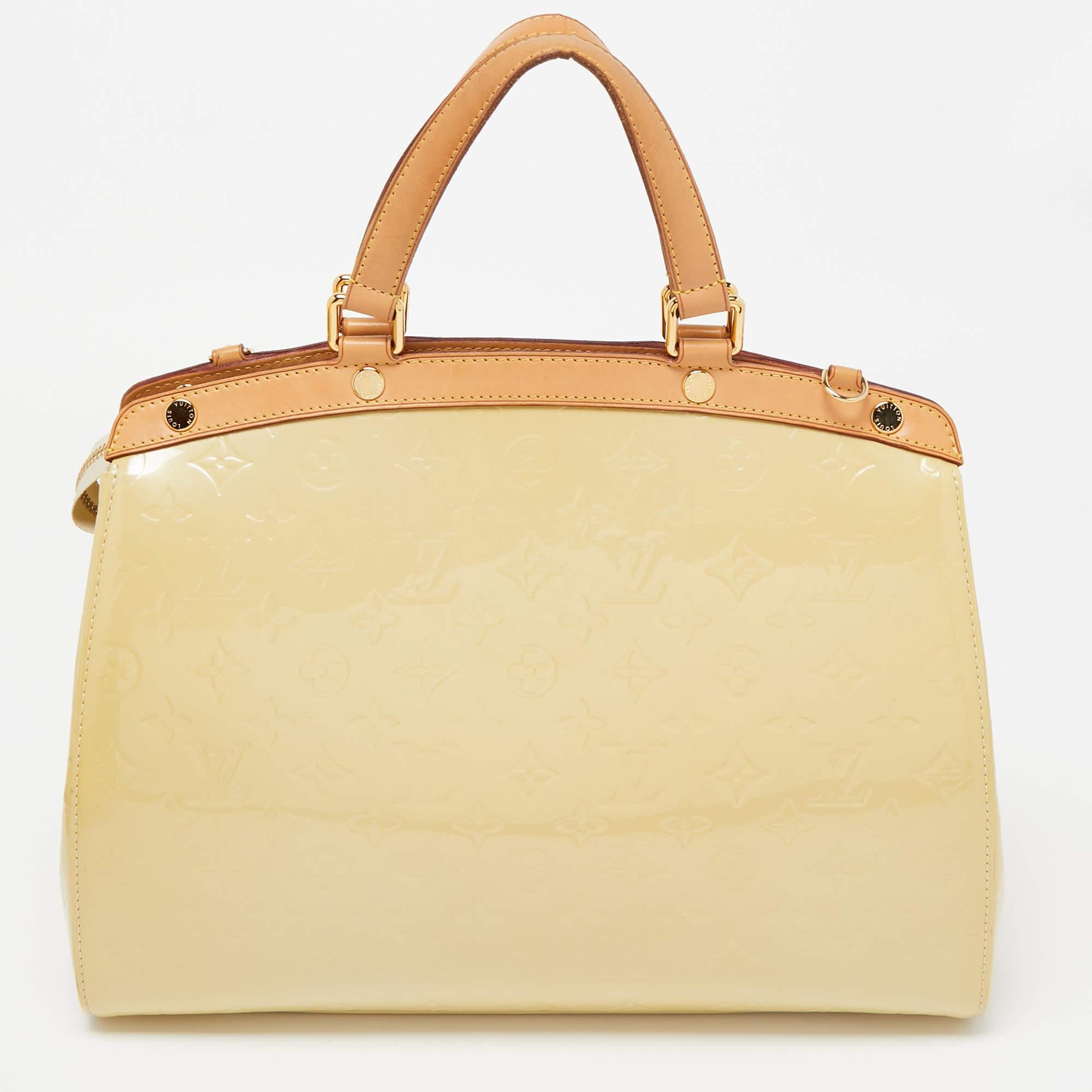 This Brea GM bag from the House of Louis Vuitton will definitely sway you away with its precise shape, style, and design. It is made from Blanc Corail Monogram Vernis into a structured, neat silhouette. It flaunts gold-toned fittings, dual top