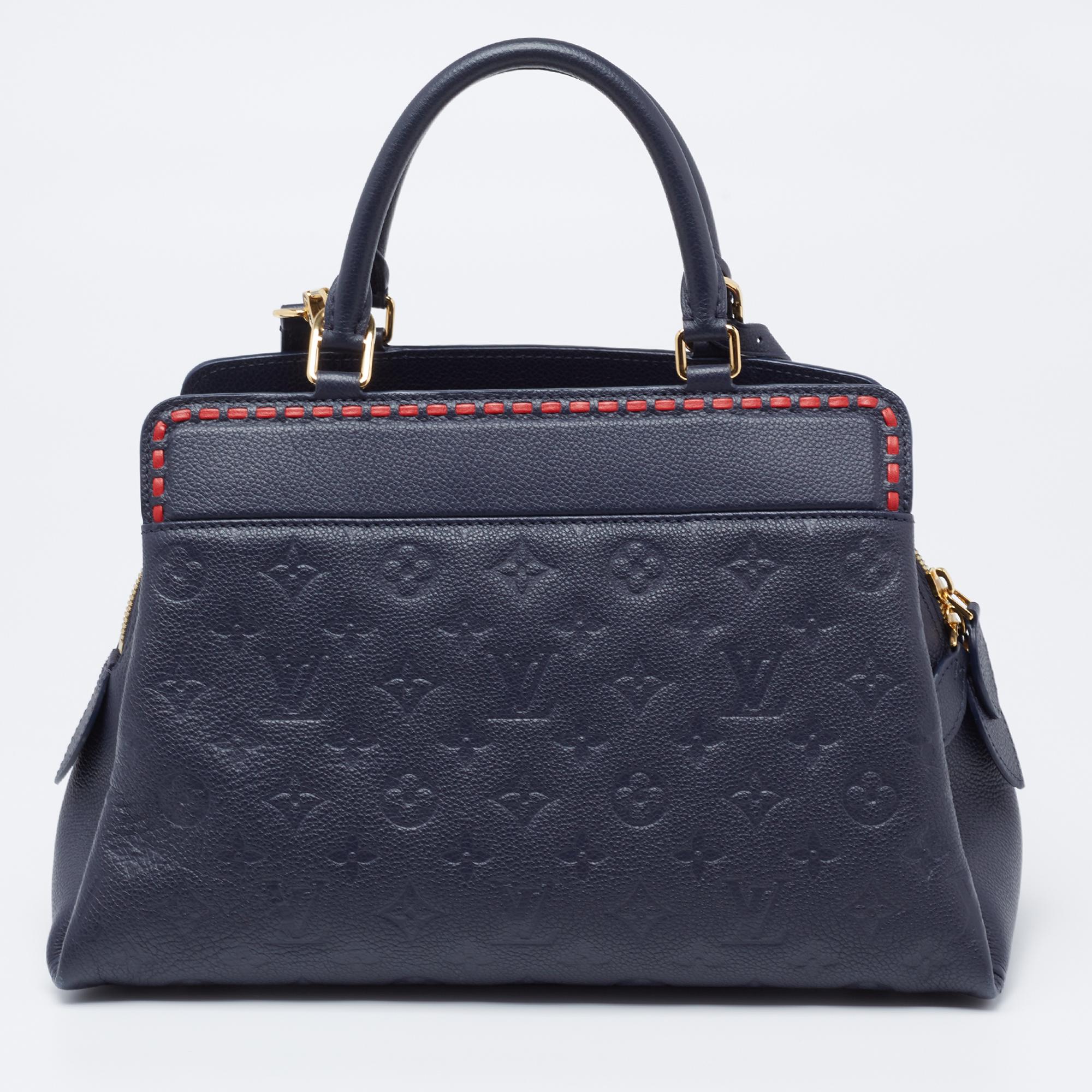 Coming from the House of Louis Vuitton, this stunning Vosges MM bag is an amazing accessory you need to own today. It is made from Bleu Infini Empreinte leather on the exterior. It is adorned with gold-tone hardware and unveils a spacious