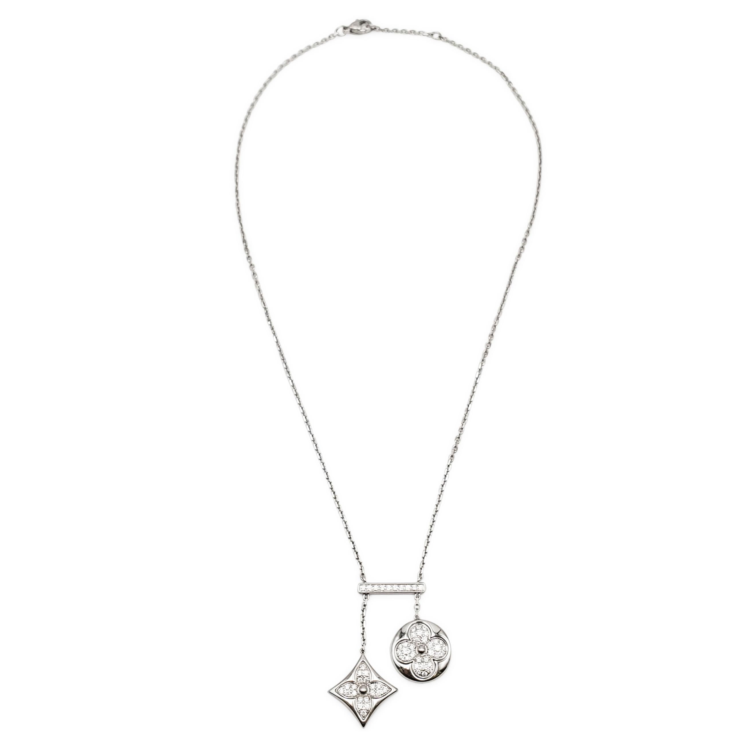 Authentic Louis Vuitton négligé necklace from the Diamond Blossom collection crafted in 18 karat white gold.  The necklace features two monogram flower motifs pave set with glittering round brilliant cut diamonds situated on a diamond set bar