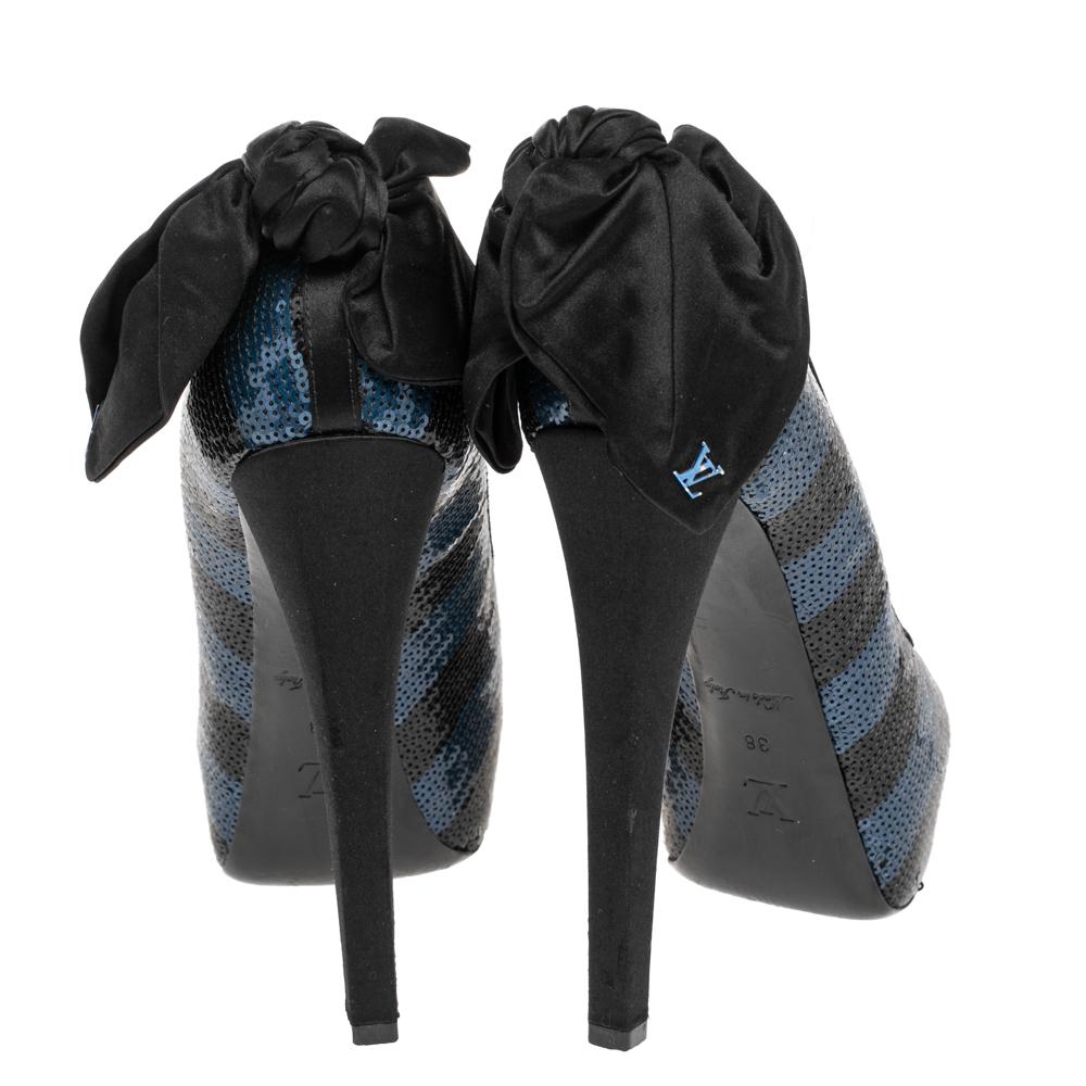 Perfect for all seasons, this pair of Louis Vuitton pumps are just what you need. These pumps are crafted in Italy and made from blue-black sequins that add a touch of glamour. They are styled with peep toes, platforms, 14 cm heels, and bow detail