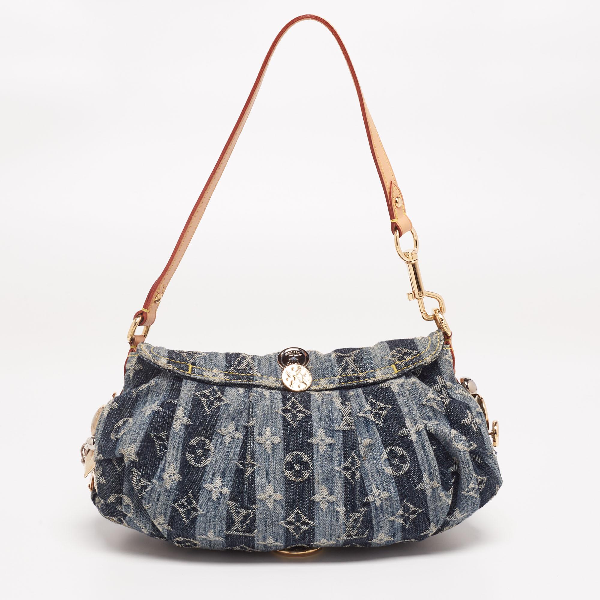 This chic handbag blends aged denim with Louis Vuitton's signature monogram, creating a luxurious finish. This petite creation features a front flap with a gold-tone closure and a single handle. The interior is lined with soft Alcantara and has