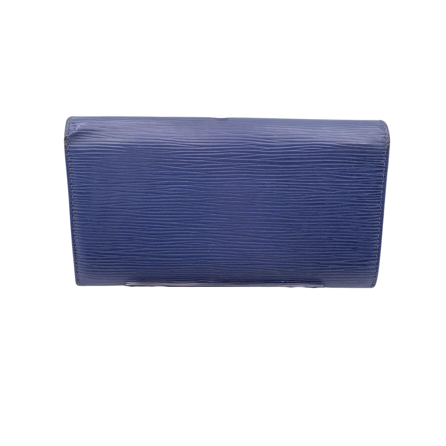 Louis Vuitton 'Sarah' wallet, in blue color. Epi leather. Interior fully lined in leather. Flap with snap closure. 2 flat open pockets under the flap. 1 coin compartment with zip closure. 2 bill compartments. 4 credit card slots and 1 flat open
