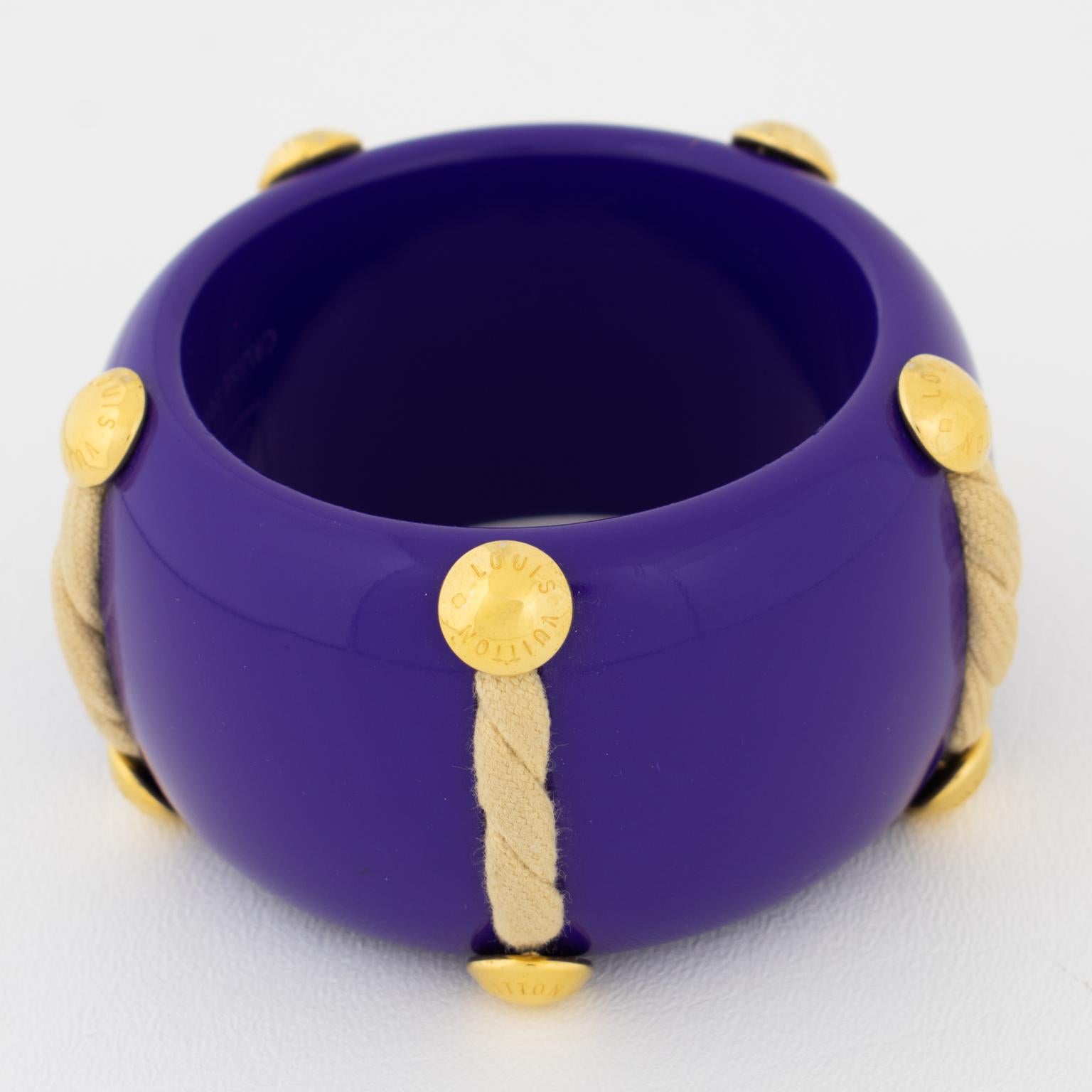 Questo splendido braccialetto bangle Louis Vuitton appartiene alla Limited Edition Louis Vuitton 2010 Cruise Collection. Il braccialetto nautico estivo è caratterizzato da un corpo in acetato o lucite lucida viola-blu, ornato da dettagli in corda