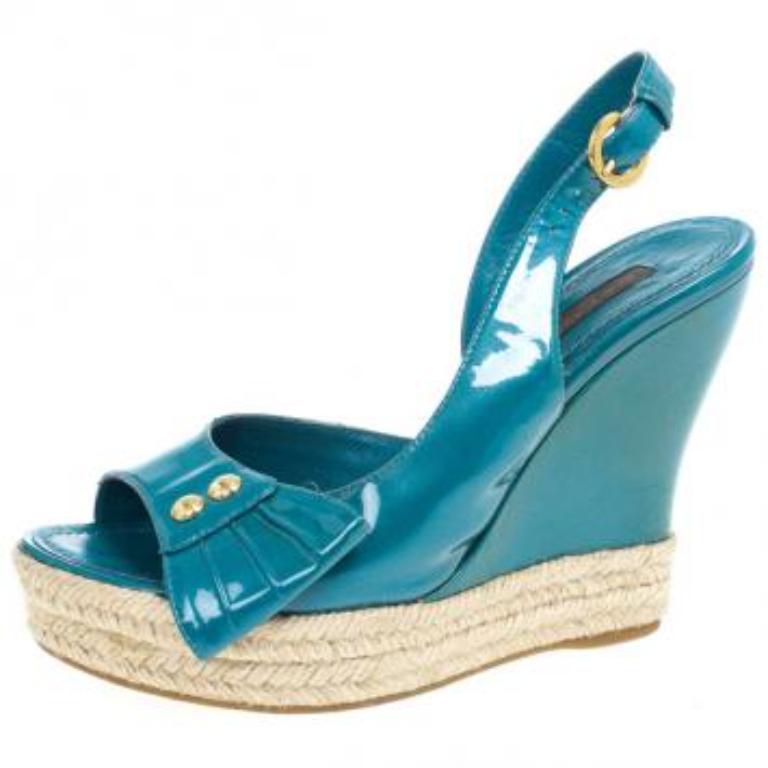 Kombinieren Sie diese glänzenden Louis Vuitton Wedges mit Ihren täglichen Looks. Sie sind aus Lackleder gefertigt und mit Nietenbesatz und Plissee-Details an den Vamps ausgestattet. Sie sind mit Schnallenverschlüssen am Knöchel
