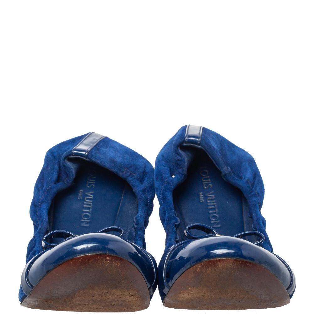 Treat your feet with these ballet flats from Louis Vuitton that offer both style and comfort. The blue flats are crafted from patent leather & suede and feature delicate bows with gold-tone brand logo detailing on the vamps. Their scrunch fit