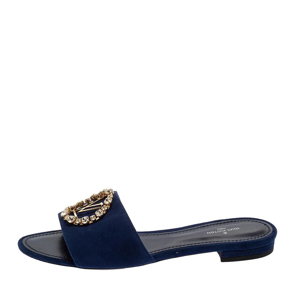 Simple and comfortable, these mules from Louis Vuitton are worth every penny you spend! The slides feature blue-hued suede straps with the LV logo over the vamps forming an open toe silhouette. They are further accented with crystal embellishments.