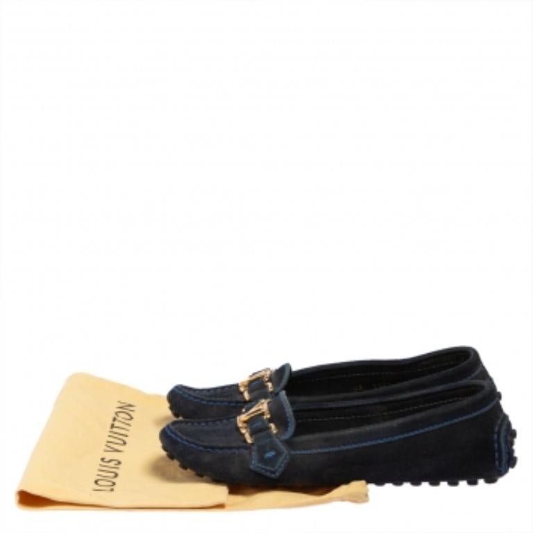 Achieve a sophisticated style when you wear these Louis Vuitton loafers. Crafted from blue suede with stitched details, these slip-on style loafers are detailed with polished gold-tone LV buckles and distinctive rubber-pebbled soles. The insoles are