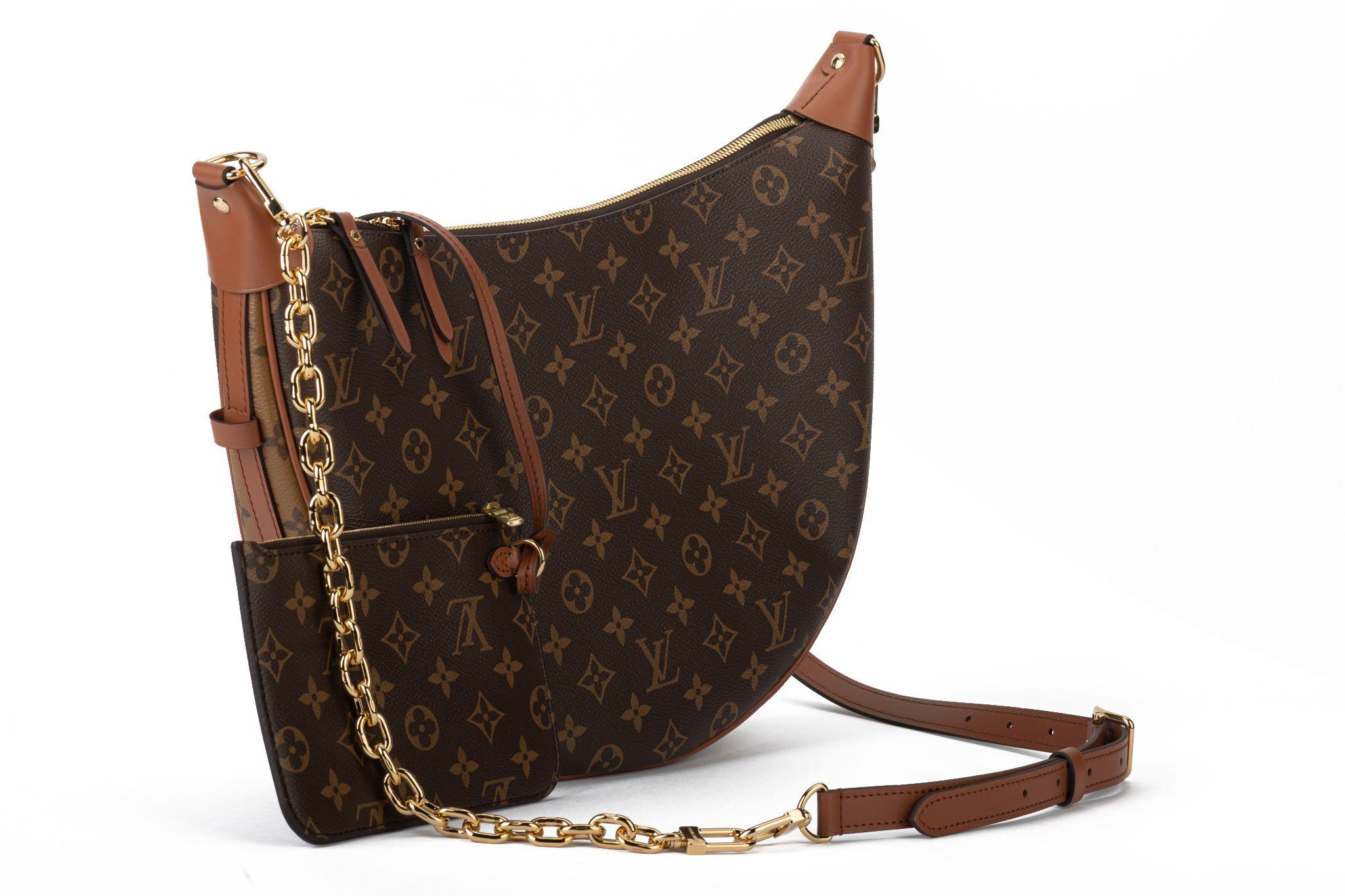 Louis Vuitton sold out worldwide new in box hobo 2 way shoulder bag. Dark leather reminiscing 70s Vuitton collections. Interchangeable leather and chain strap. Detachable mini pochette, 7”x5”. Chain Drop 7”. Leather drop 14”. Comes with original