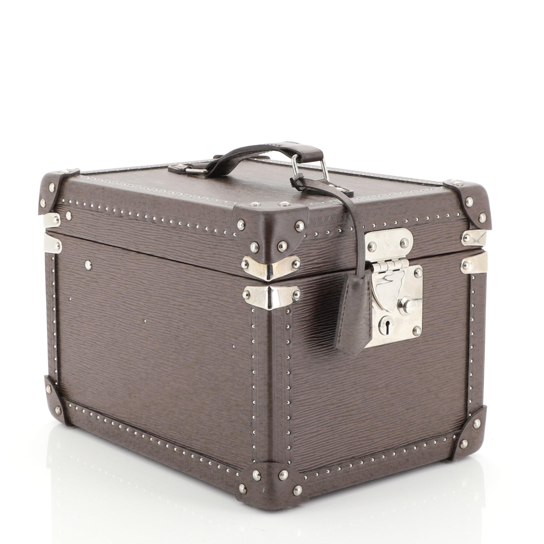 This Louis Vuitton Boite Flacons Beauty Train Case Epi Leather, crafted from brown leather, features vachetta leather top handle, leather tag, framed edges, and silver-tone hardware. Its signature S-lock closure opens to a brown microfiber interior