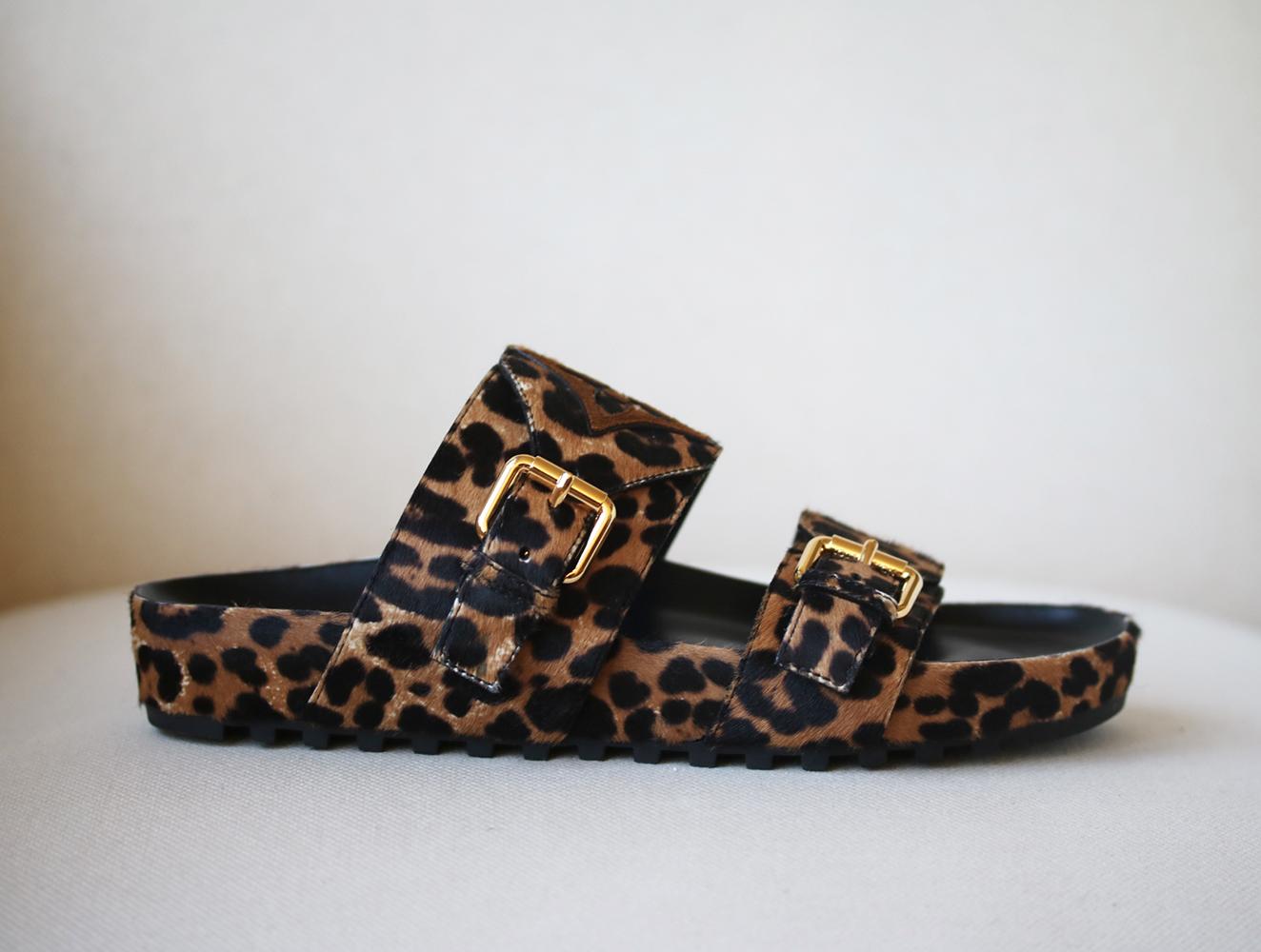 The Bom Dia Flat Mules come in pony-style calfskin with a bold leopard print as part of the LV Jungle capsule of accessories and leather goods. They are complemented by Monogram Flower patches in suede calf leather and engraved, gold-tone buckles.