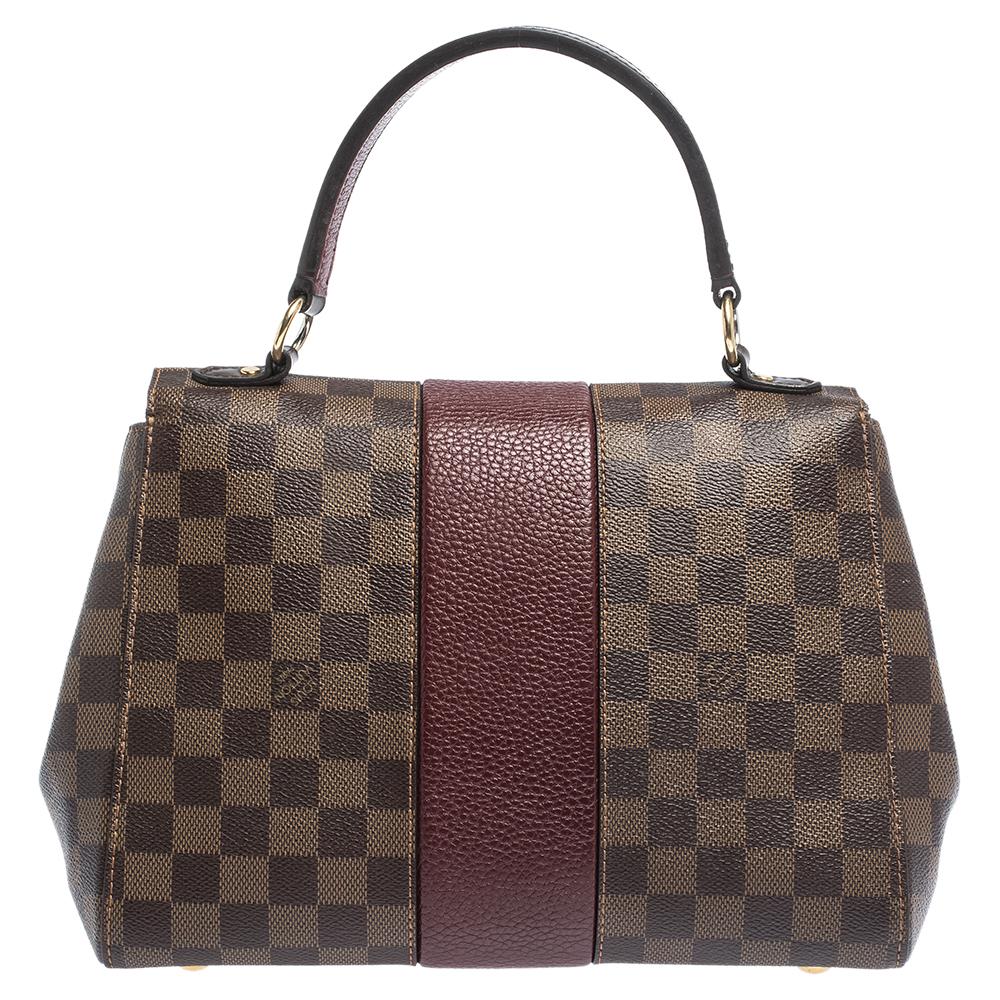 This stylish and chic Bond Street bag by Louis Vuitton comes in a lovely shade of brown. It has been crafted from the brand's signature Damier Ebene canvas and leather. Flawlessly functional, it is the perfect companion for day & night outings. It
