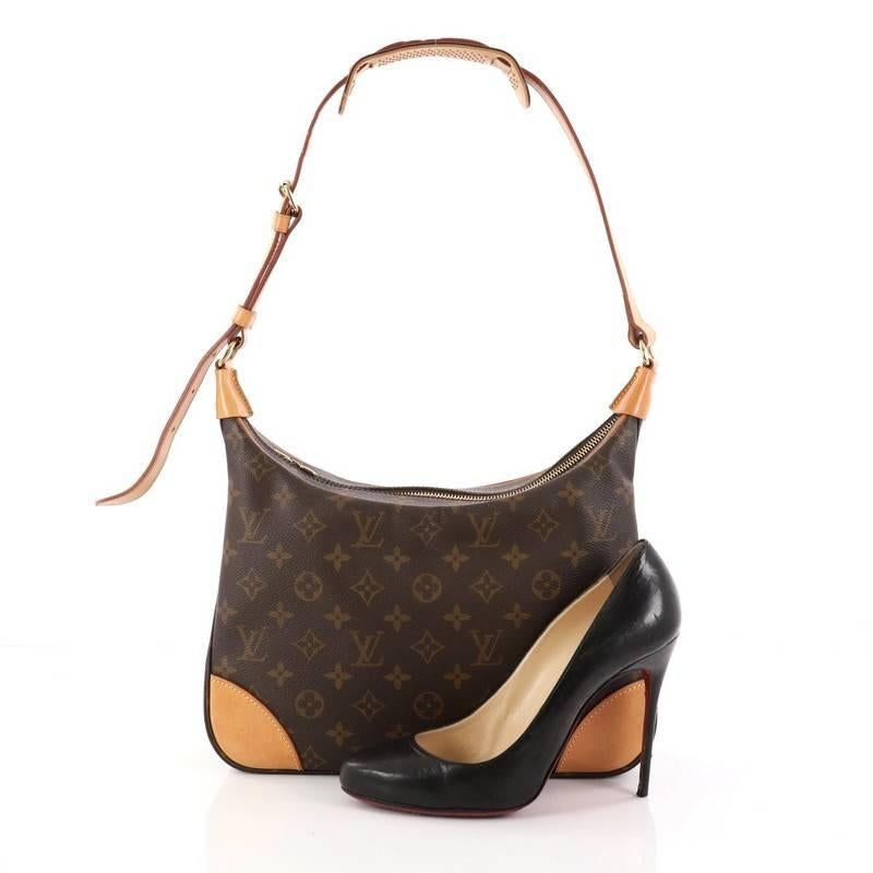 This authentic Louis Vuitton Boulogne Handbag Monogram Canvas 30 showcases a stylish design perfect for everyday use. Crafted from brown monogram coated canvas, this satchel features an adjustable vachetta leather strap, vachetta leather trims, and