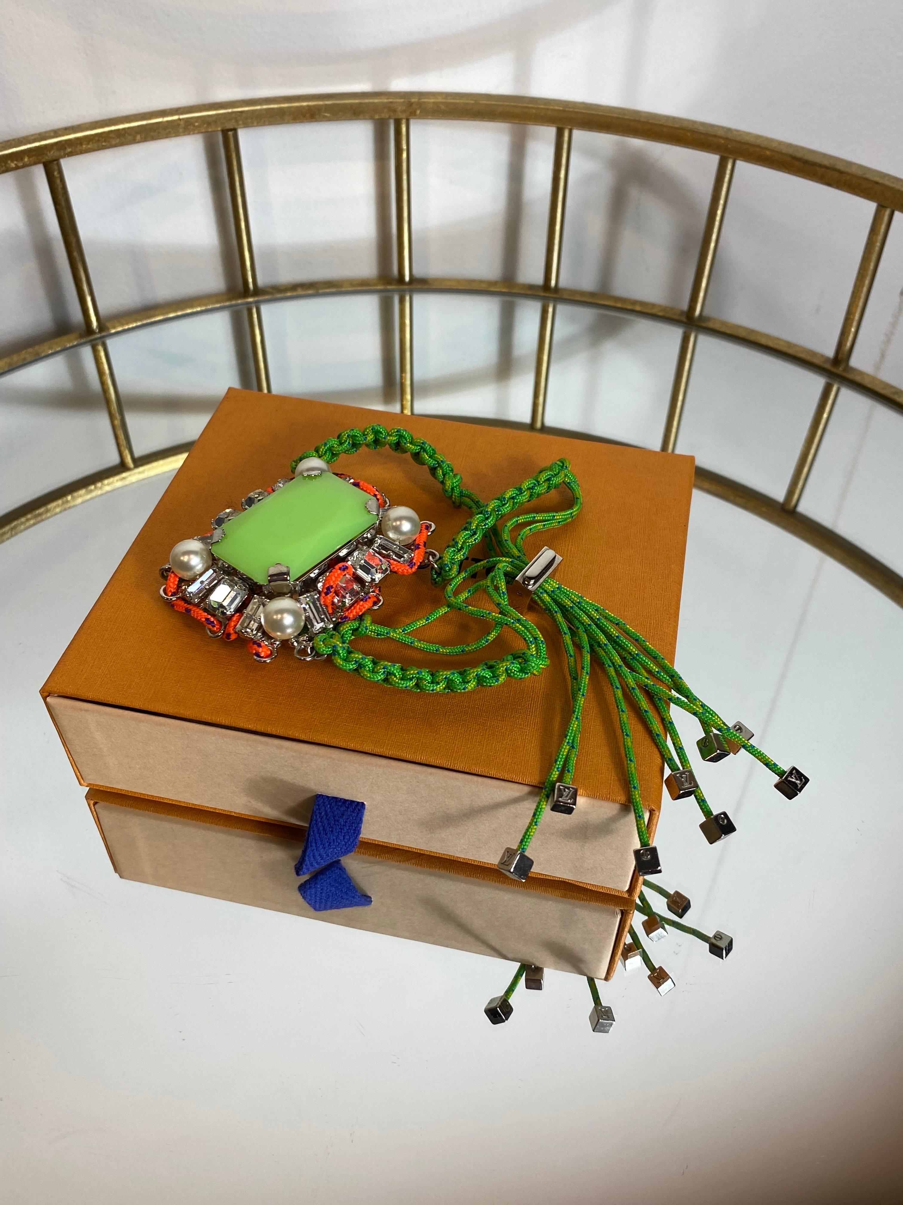 Louis Vuitton bracelet in semi-precious stones, faux pearls and multicolored woven fabric. The bracelet can be adjusted by means of a silver metal hook. Central green stone. 
Central part 5x7 cm. 
With dust and original box. 
In excellent condition