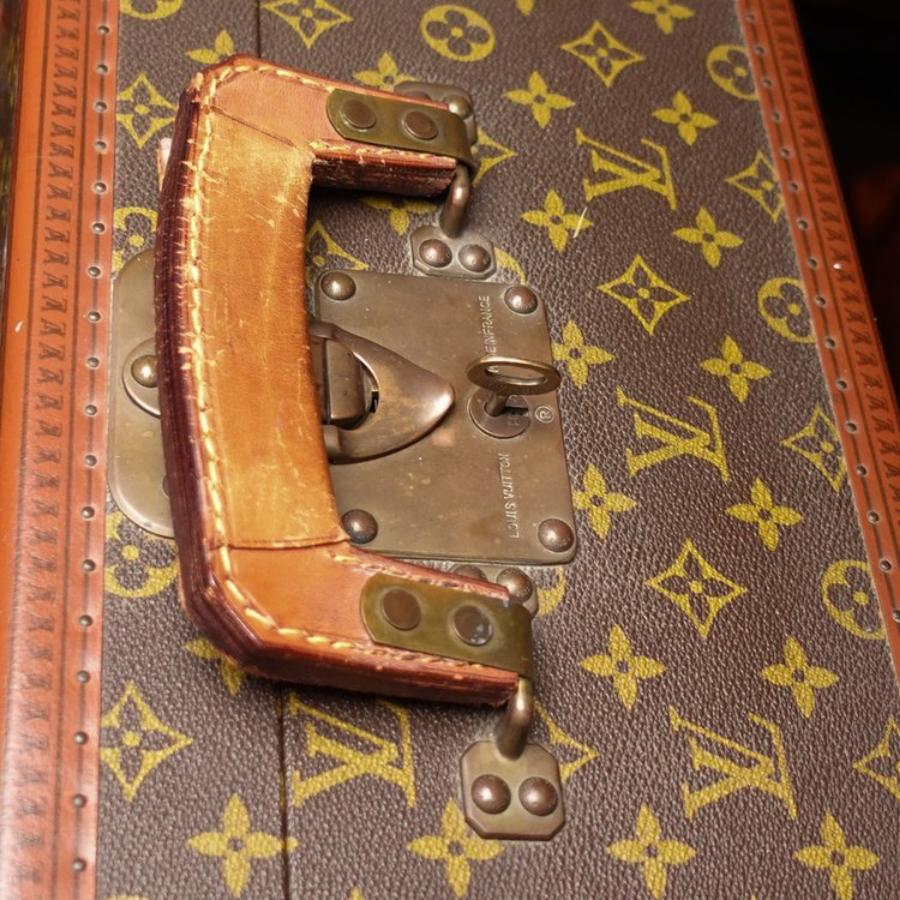 Composite, leather and brass bound with leather handle. Lined in cream leather. The two interior ivory colored canvas cross straps are not usable. Missing interior label. The lock of the Braken stamped 'LV LOUIS VUITTON MADE IN FRANCE H3'. Original