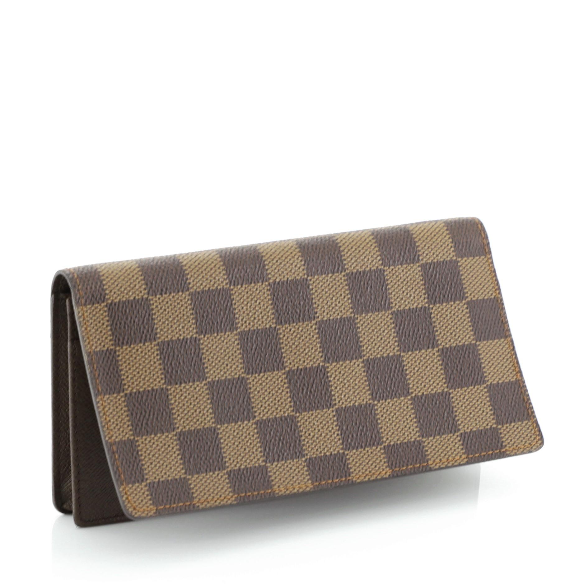 This Louis Vuitton Brazza Wallet Damier, crafted in damier ebene coated canvas. It opens to a brown leather interior with multiple card slots and zip and slip pockets. Authenticity code reads: CT0073. 

Estimated Retail Price: $705
Condition: Great.