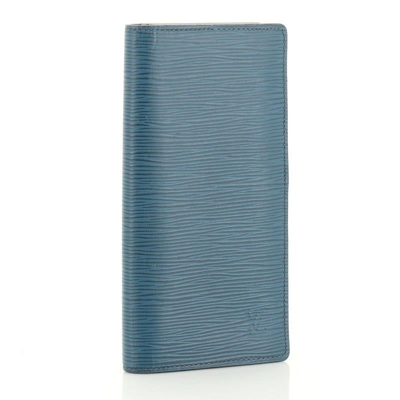 This Louis Vuitton Brazza Wallet Epi Leather, crafted in blue epi leather, features silver-tone hardware. It opens to a blue leather interior with multiple card slots and zip and slip pockets. Authenticity code reads: CA0127. 

Estimated Retail