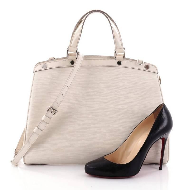 This authentic Louis Vuitton Brea Handbag Epi Leather GM is a staple for an everyday look. Crafted from off-white epi leather, this structured yet feminine tote features dual flat leather handles, engraved LV studs, subtle LV logo, protective base