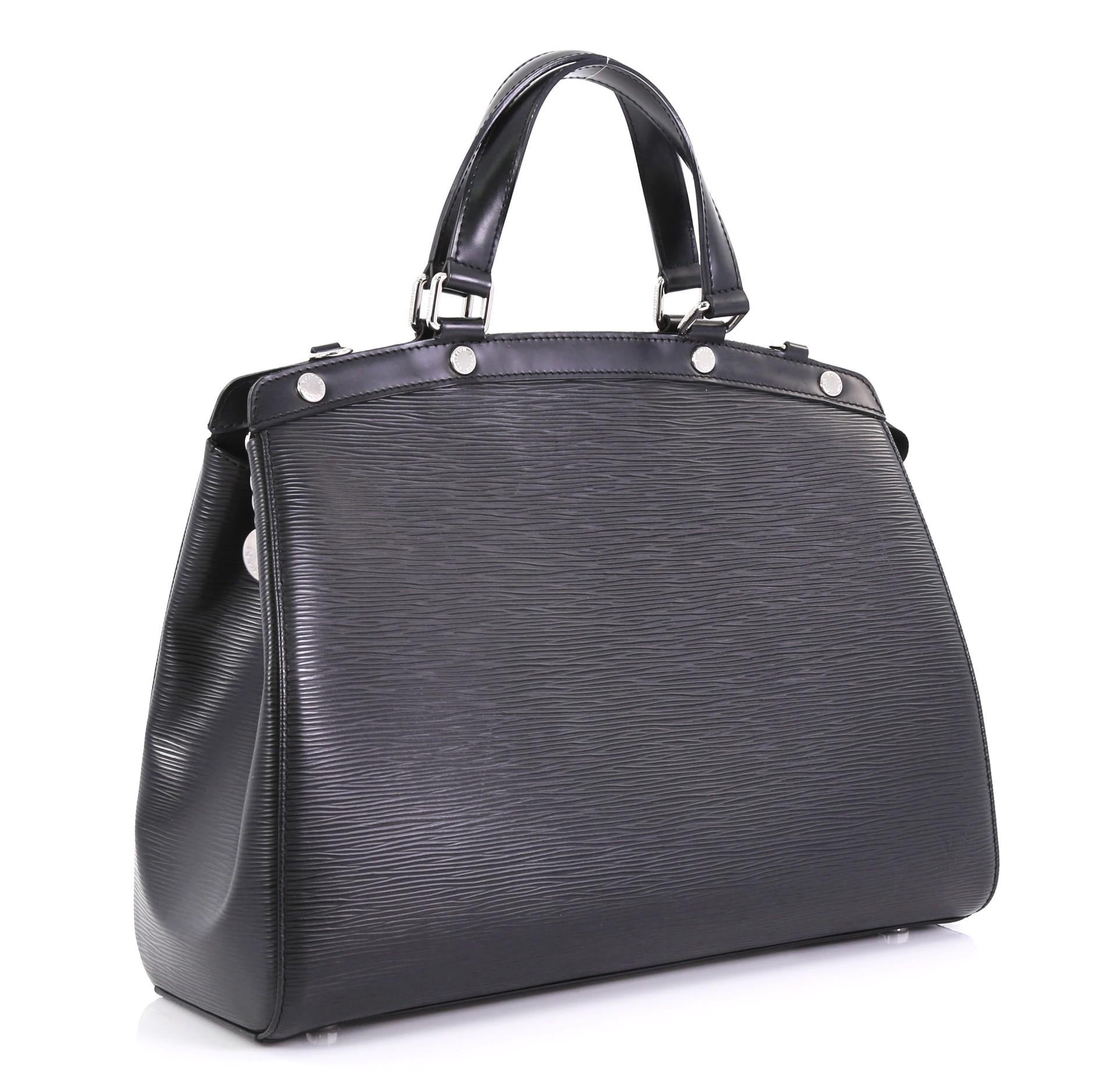 This Louis Vuitton Brea Handbag Epi Leather GM, crafted from black epi leather, features dual flat leather handles, engraved LV studs, subtle LV logo, protective base studs, and silver-tone hardware. Its zip closure opens to a black fabric interior