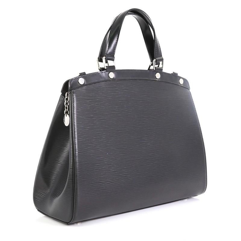 This Louis Vuitton Brea Handbag Epi Leather GM, crafted in black epi leather, features dual flat handles, protective base studs, and silver-tone hardware. Its zip closure opens to a black fabric interior with zip and slip pockets. Authenticity code