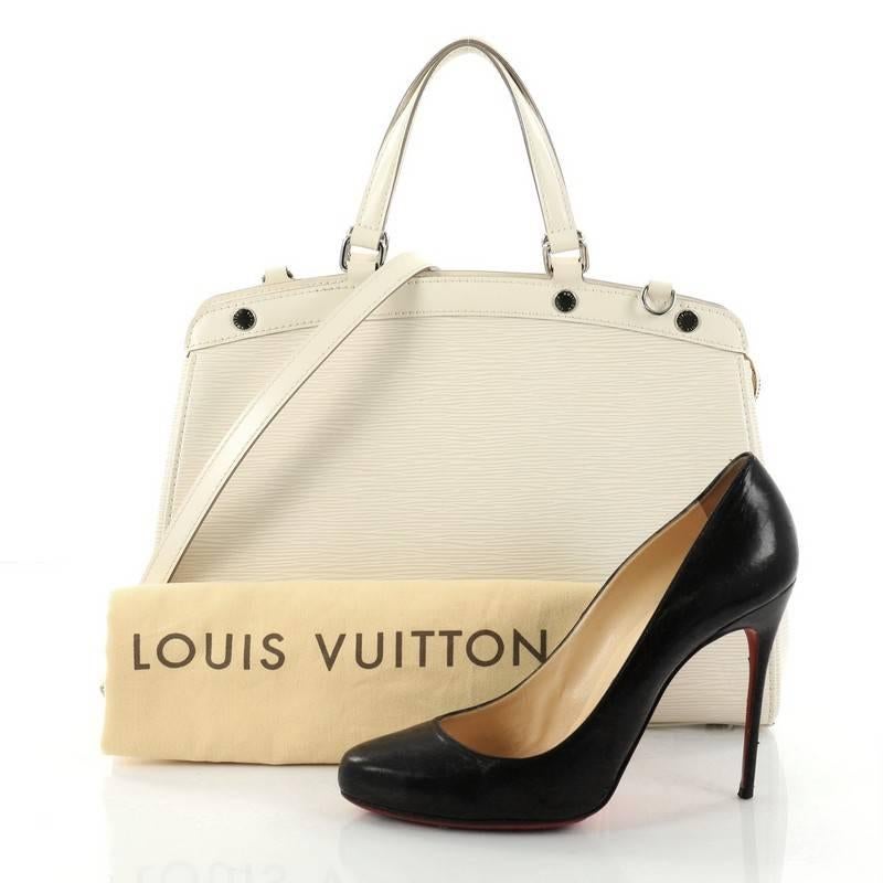 This authentic Louis Vuitton Brea Handbag Epi Leather MM is a staple for an everyday casual look. Crafted from off-white epi leather, this structured yet feminine tote features dual flat leather handles, engraved LV studs, subtle logo, protective